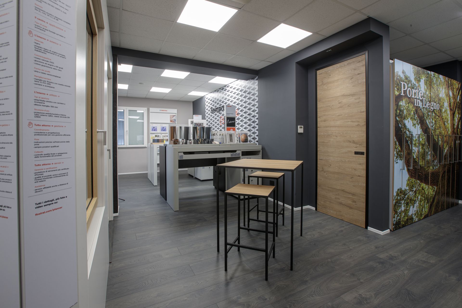 Showroom interno con tavoli, sgabelli ed espositori per i prodotti.