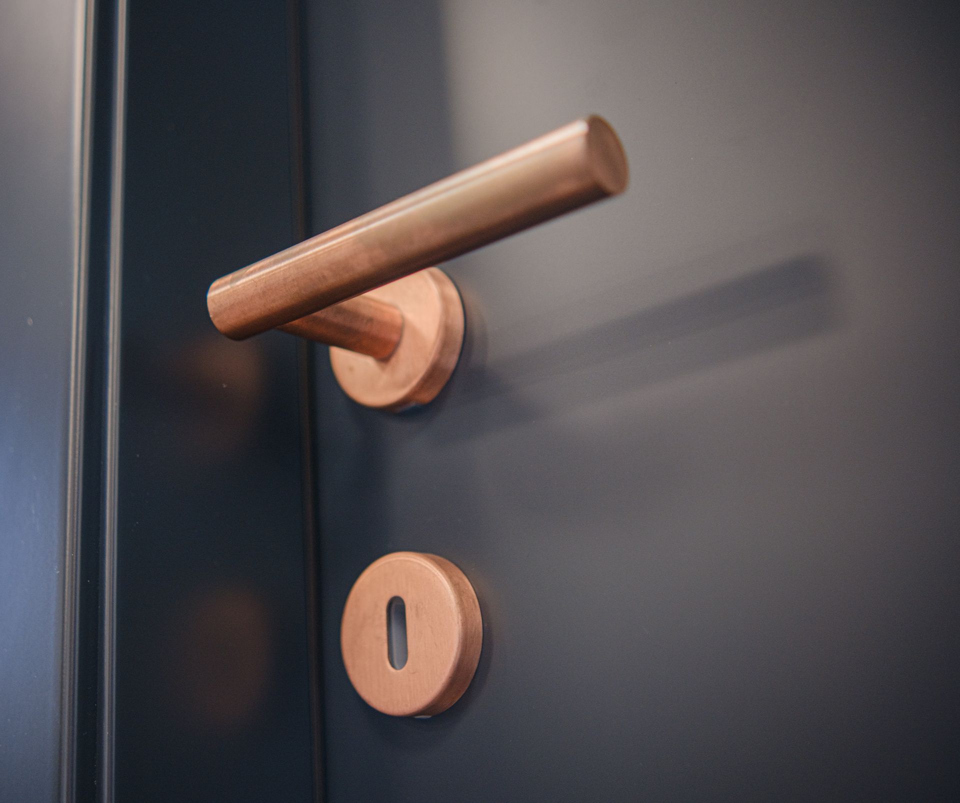 Maniglia e serratura in rame su una porta blu scuro.
