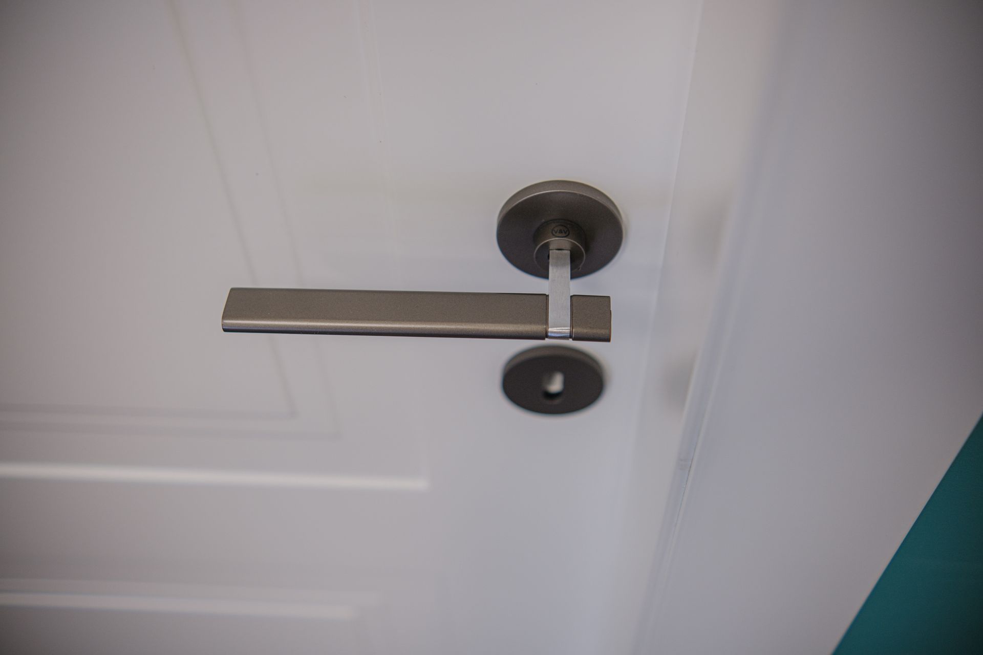 Porta bianca con maniglia metallica e serratura.