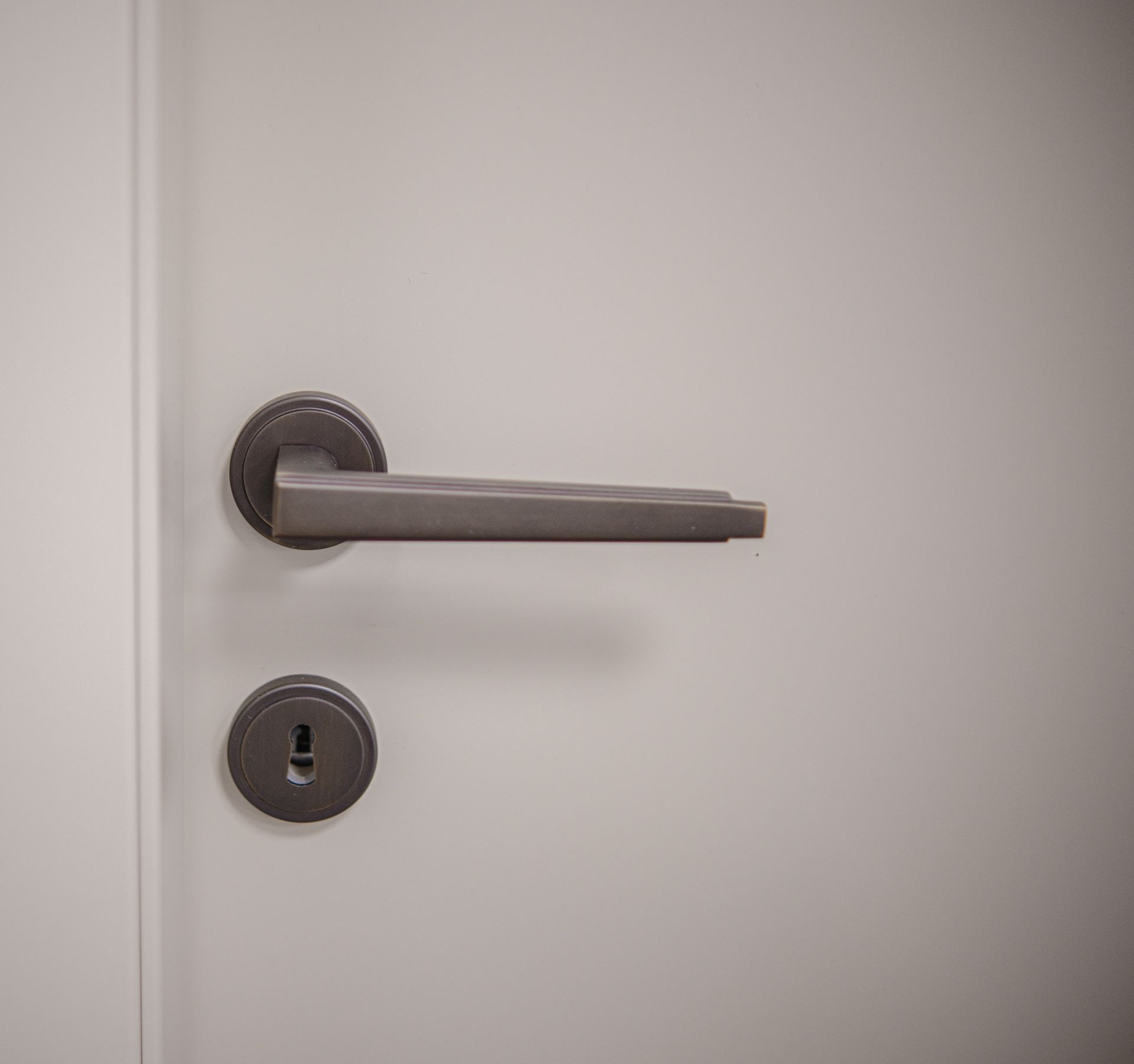 Porta grigia con maniglia e serratura scure.