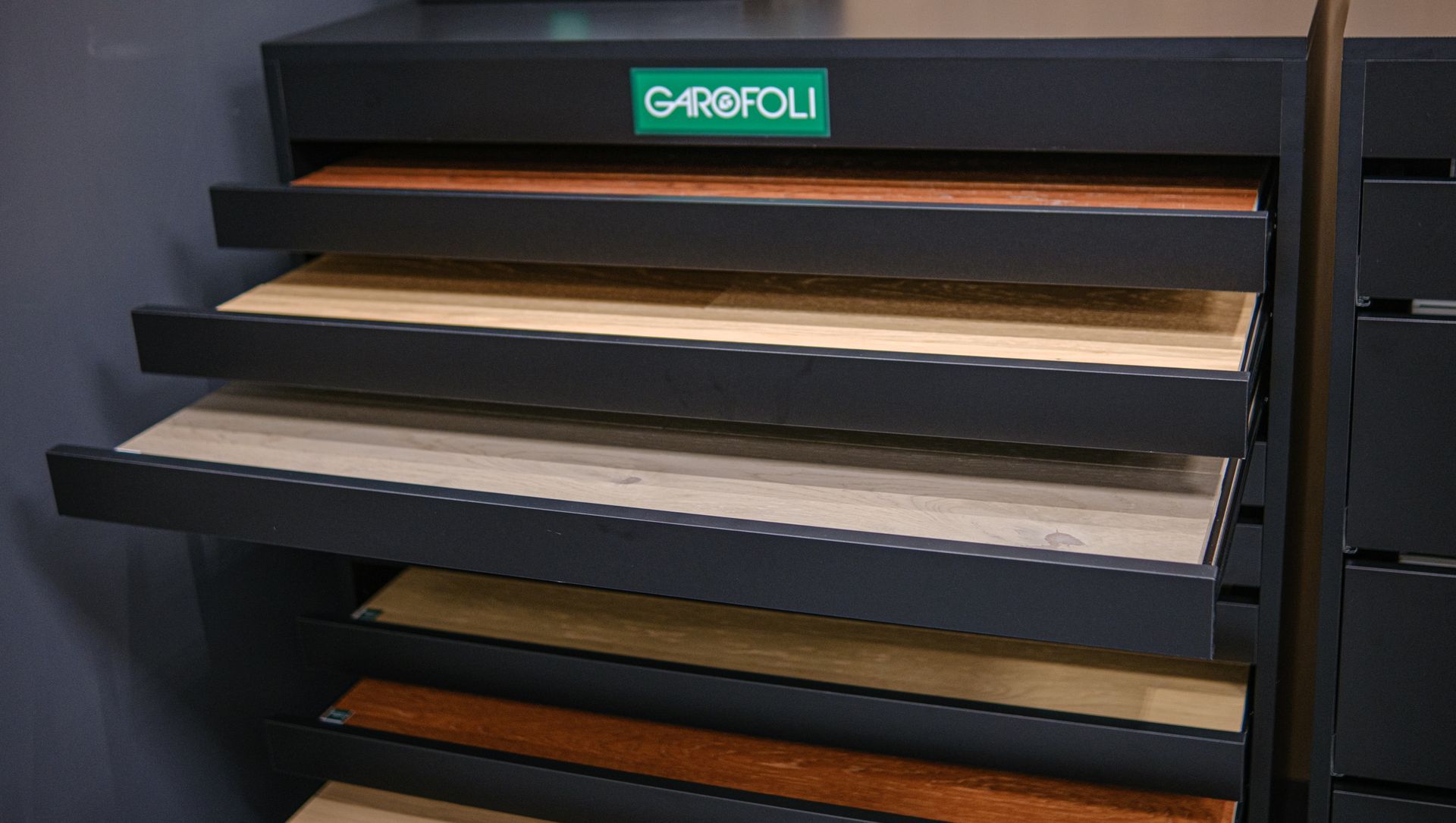 Espositore con vari campioni di pavimenti in legno in diversi colori e venature.