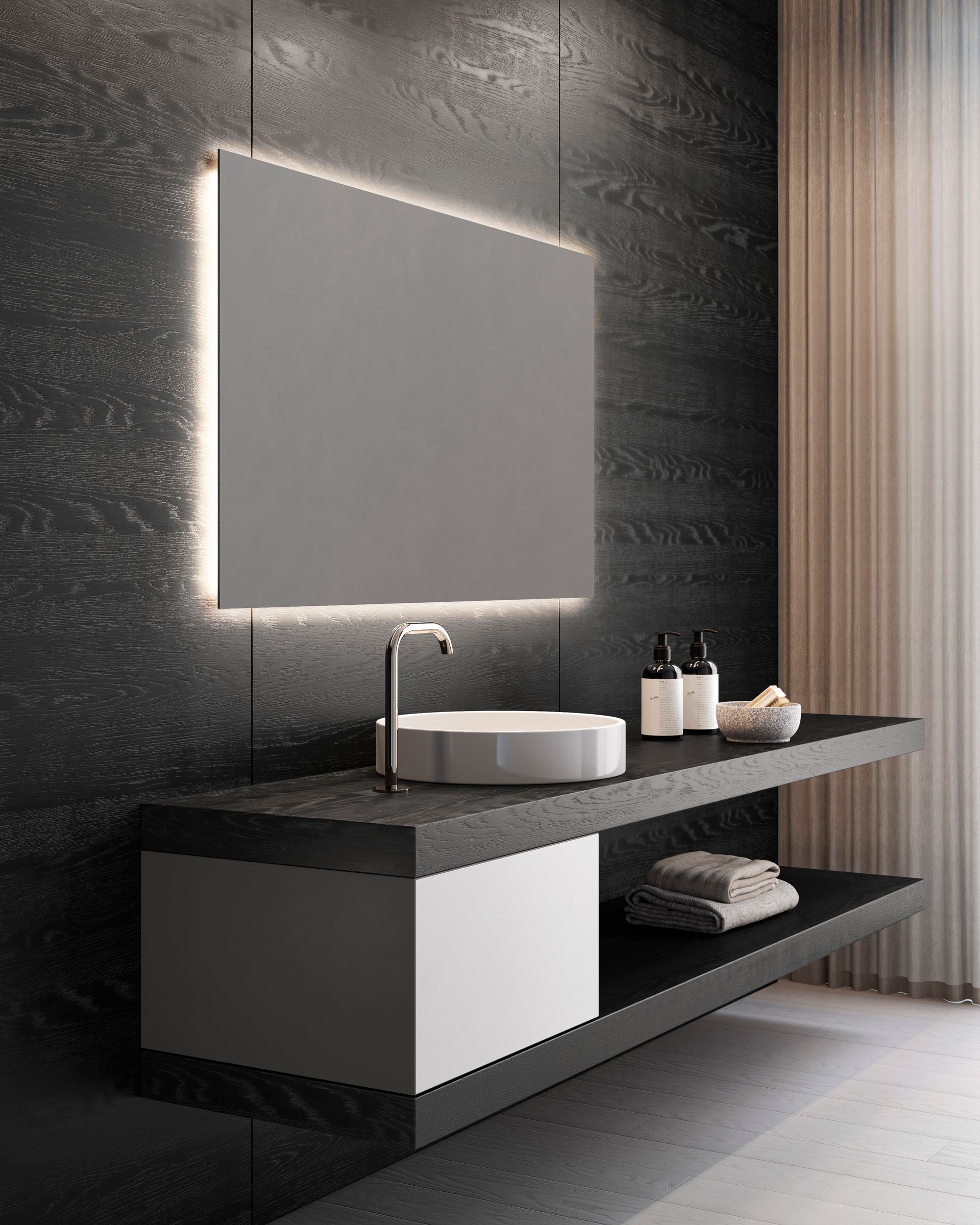 Bagno moderno con specchio retroilluminato sopra un mobile lavabo sospeso con lavabo bianco. Pareti, asciugamani e articoli da toeletta grigio scuro.