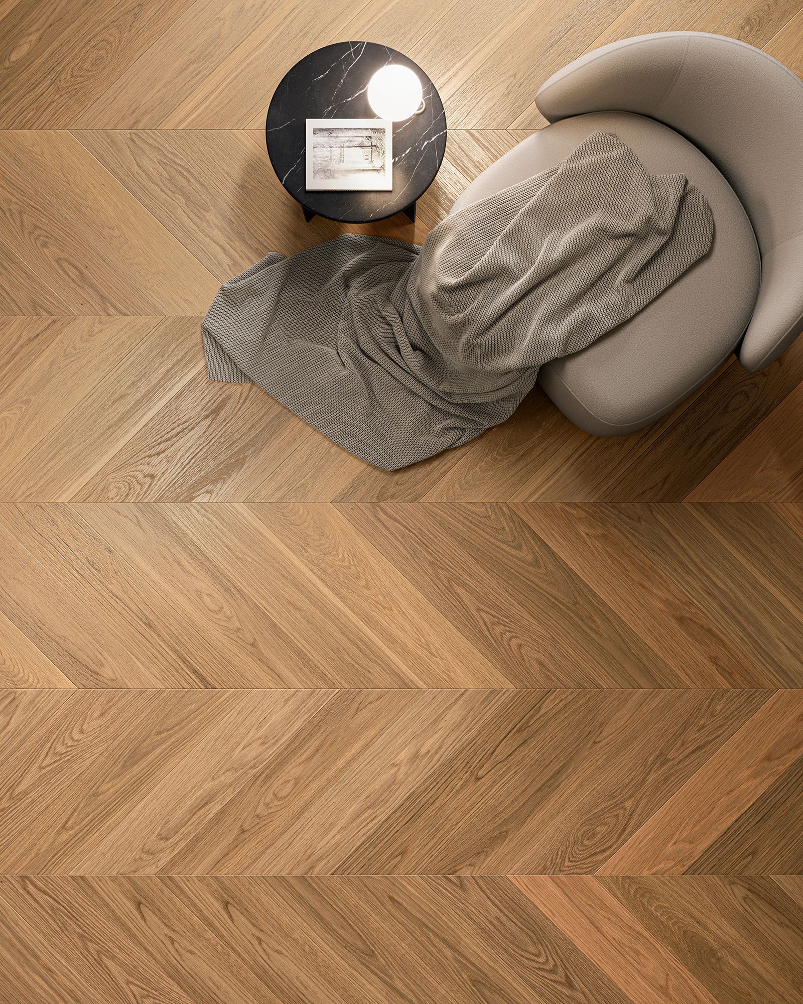 Pavimento in legno a spina di pesce con poltrona, tavolino e coperta.