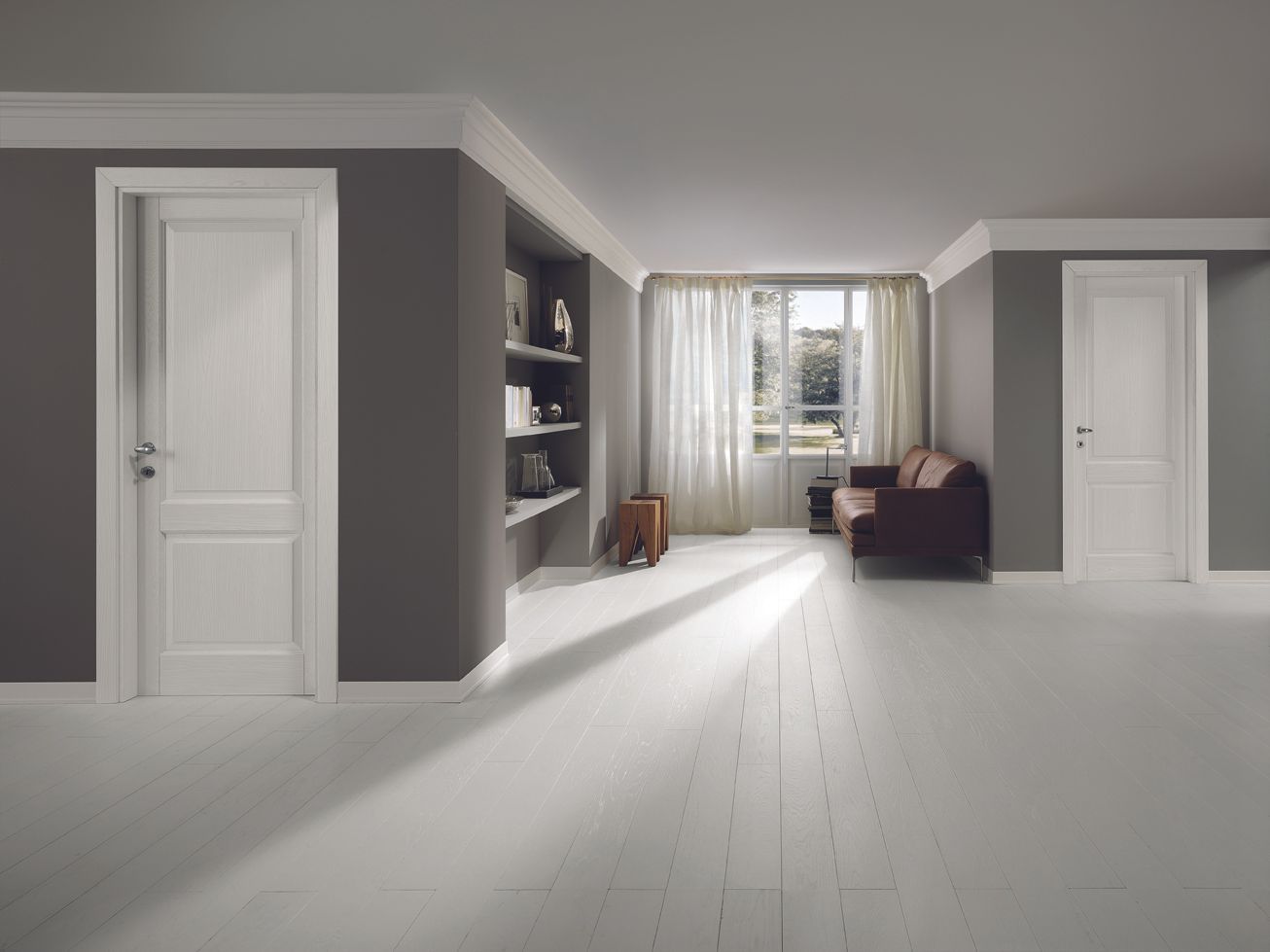 Stanza vuota con porte bianche, pavimenti bianchi, pareti grigio scuro e libreria incorporata.