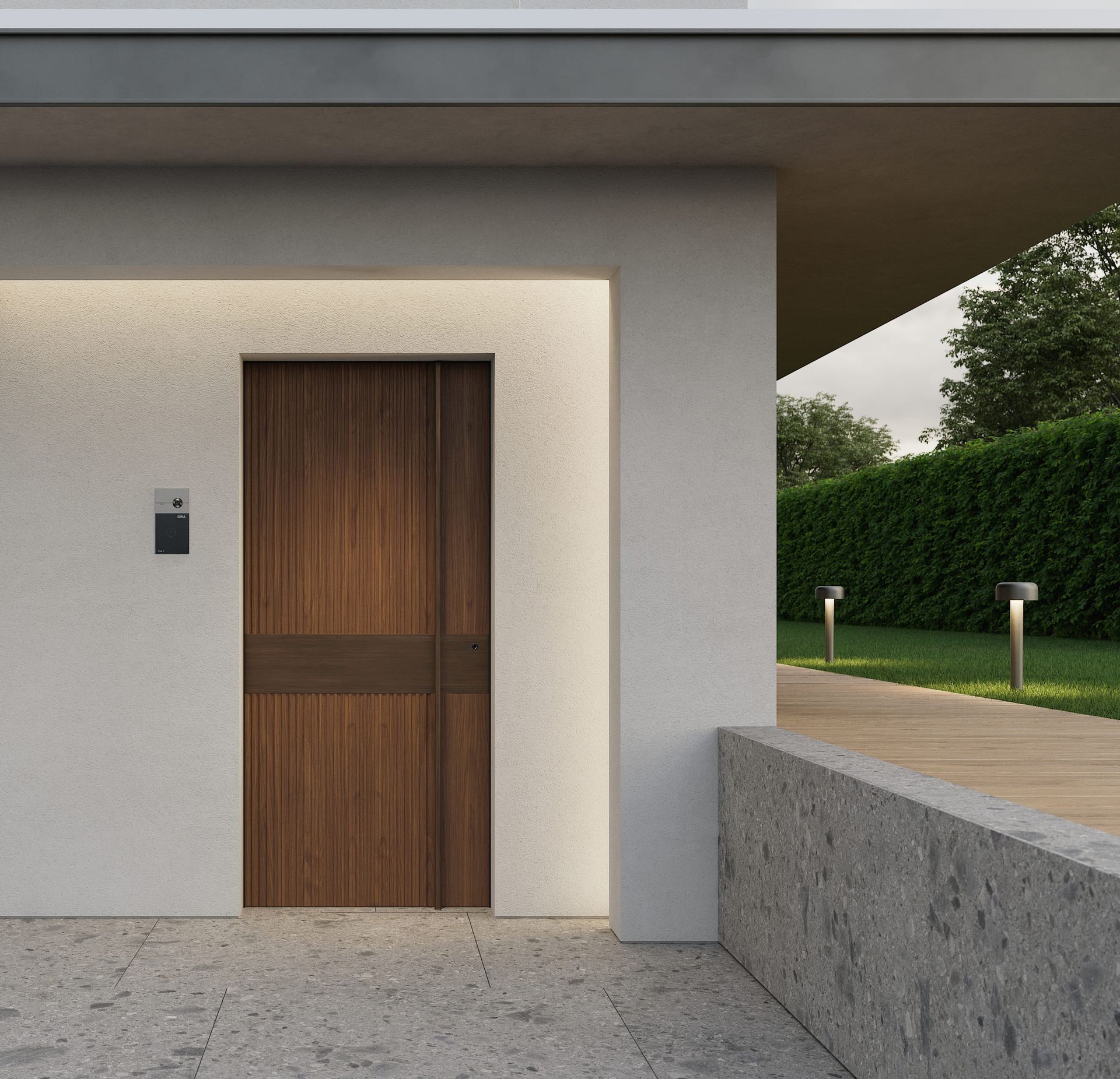 Una moderna porta di legno su un edificio in stucco bianco con un patio in cemento e un prato ben curato.