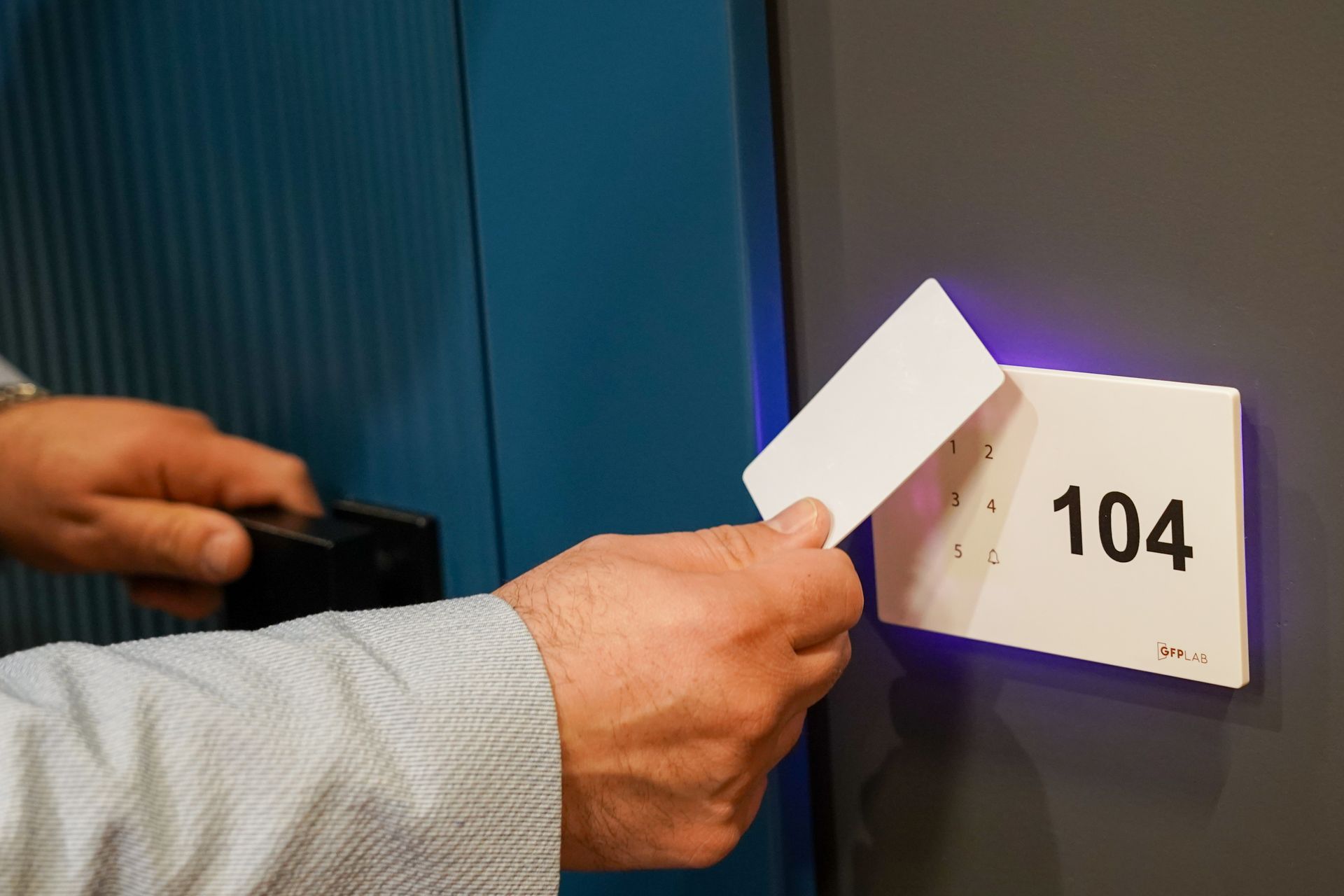 Persona che passa una tessera bianca sulla porta di una camera d'albergo con la scritta 