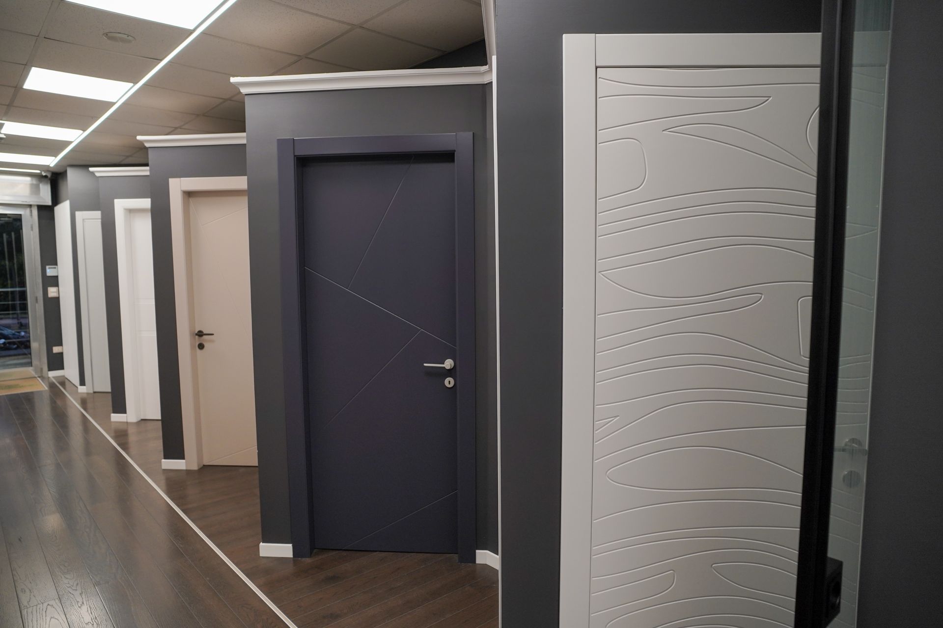 Showroom con numerose porte interne in diversi colori e stili.