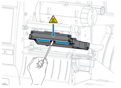 A hand uses a cotton swab to clean a printer's black toner cartridge, marked with a warning symbol for hot surfaces.