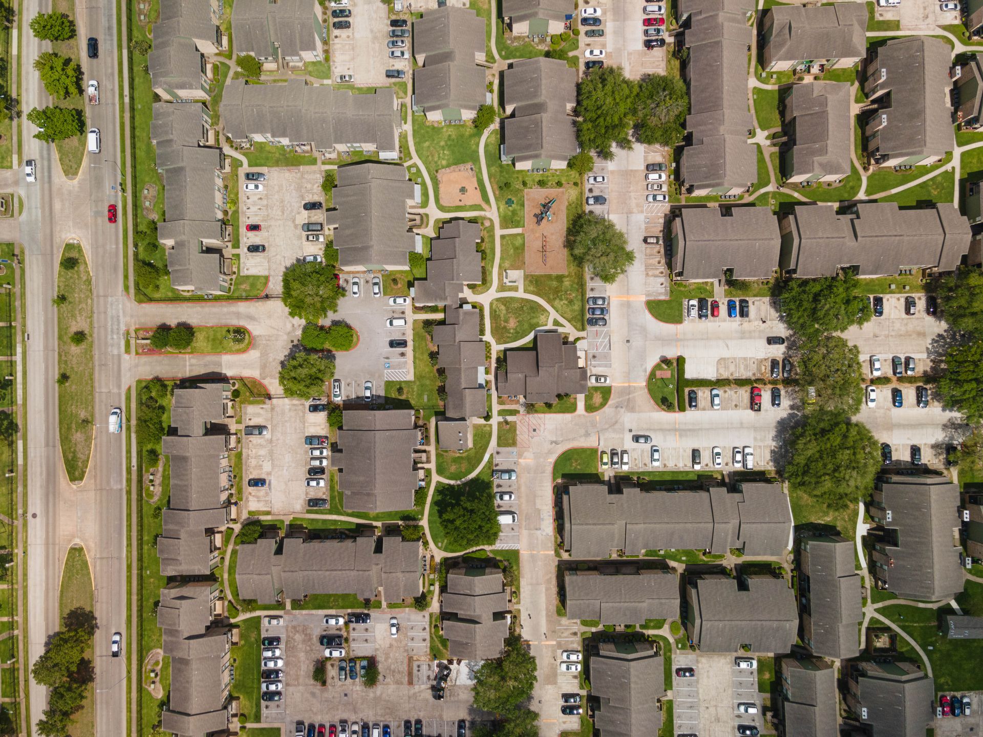 An aerial view of a residential area with lots of houses and parking lots.