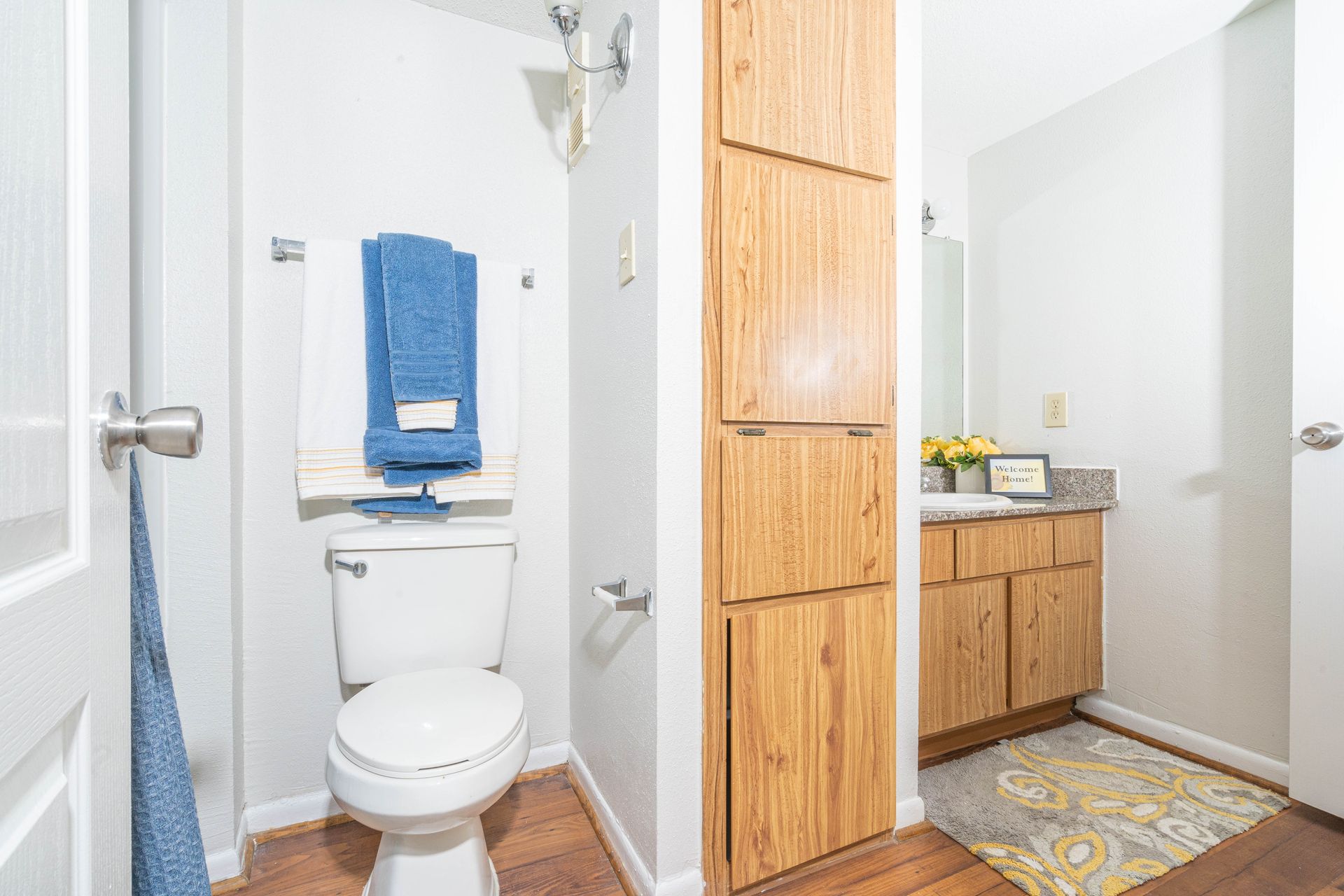 A bathroom with a toilet , sink and mirror.