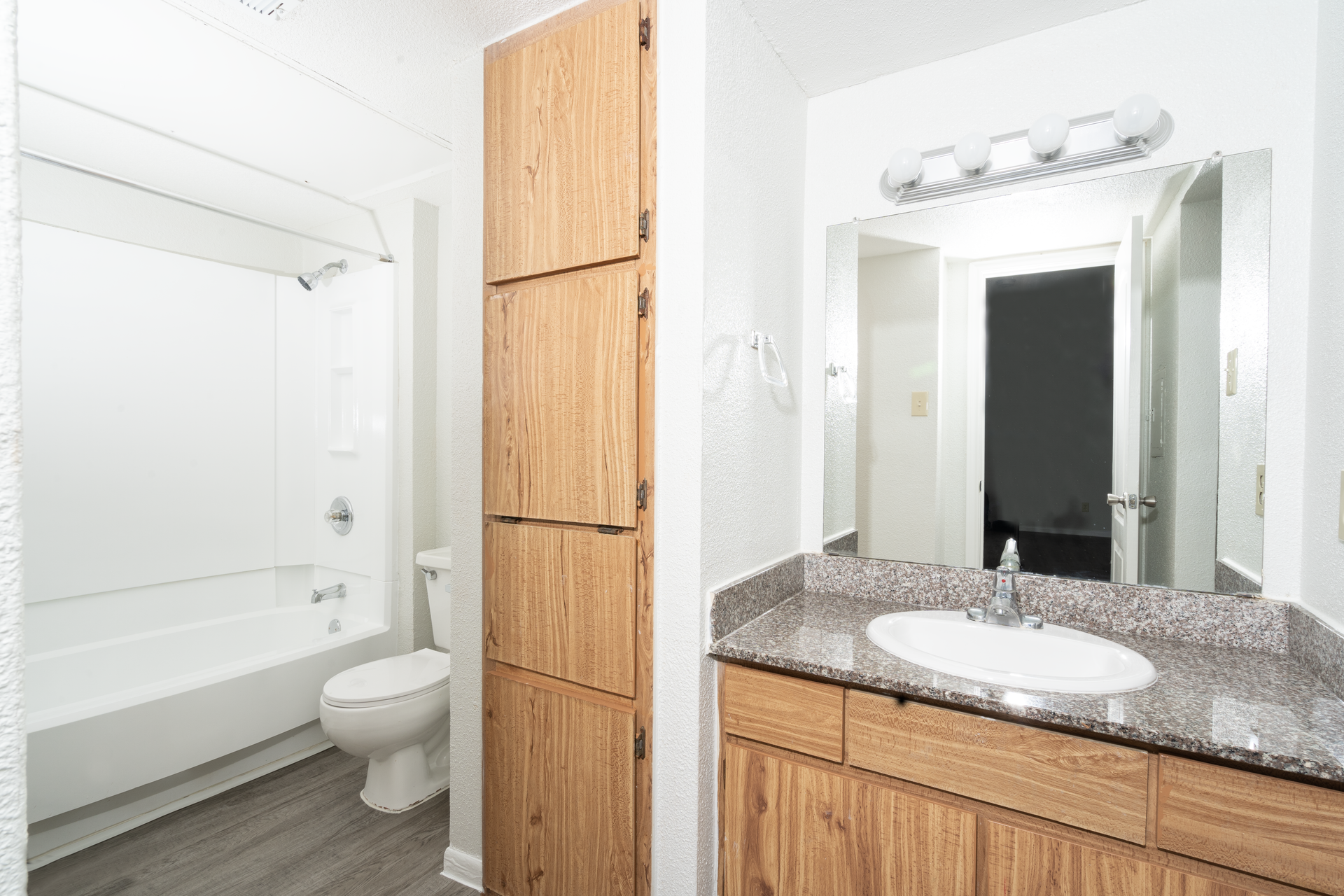 A bathroom with a sink , toilet , bathtub and mirror.