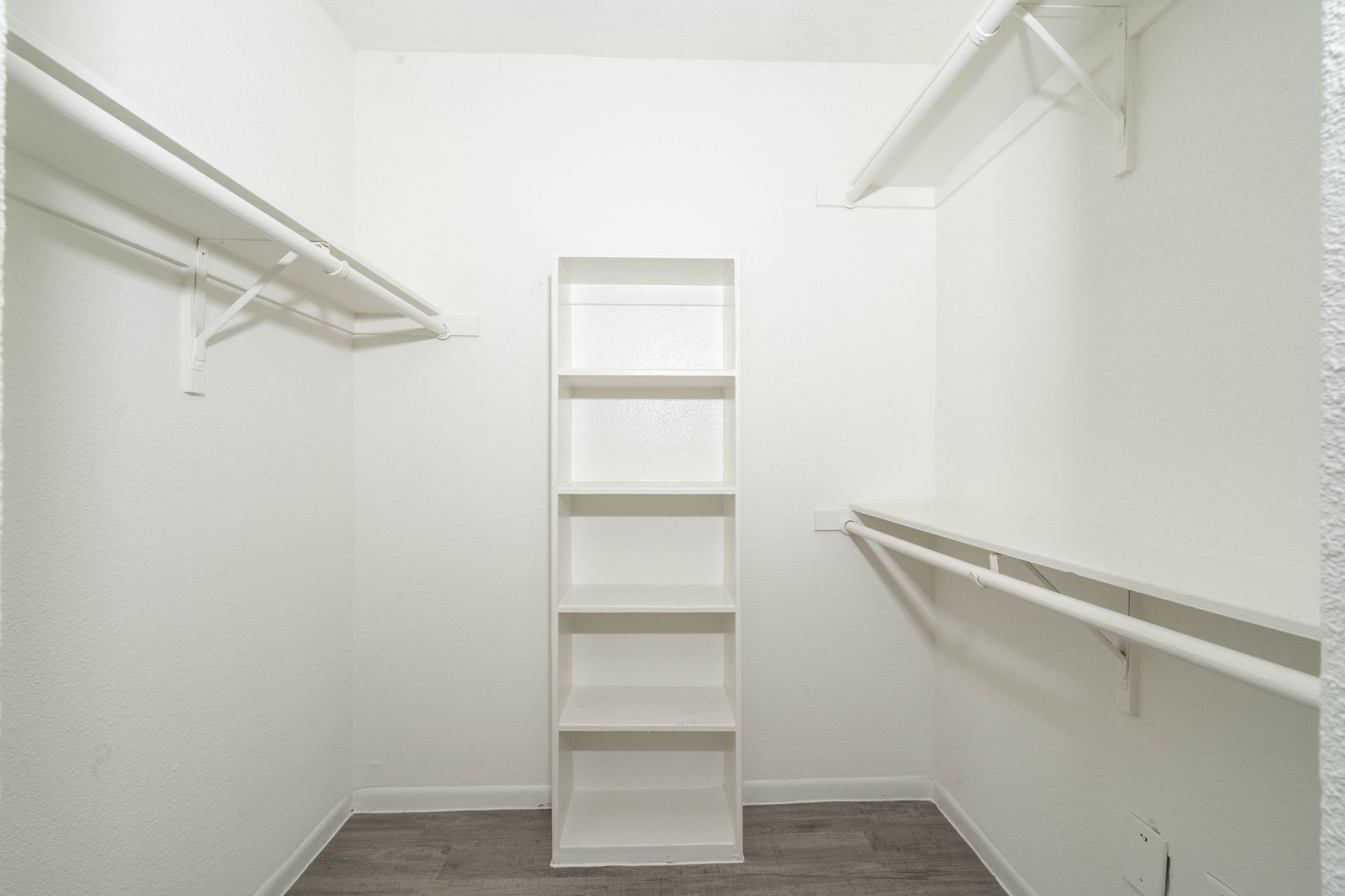 An empty walk in closet with a shelf and shelves.