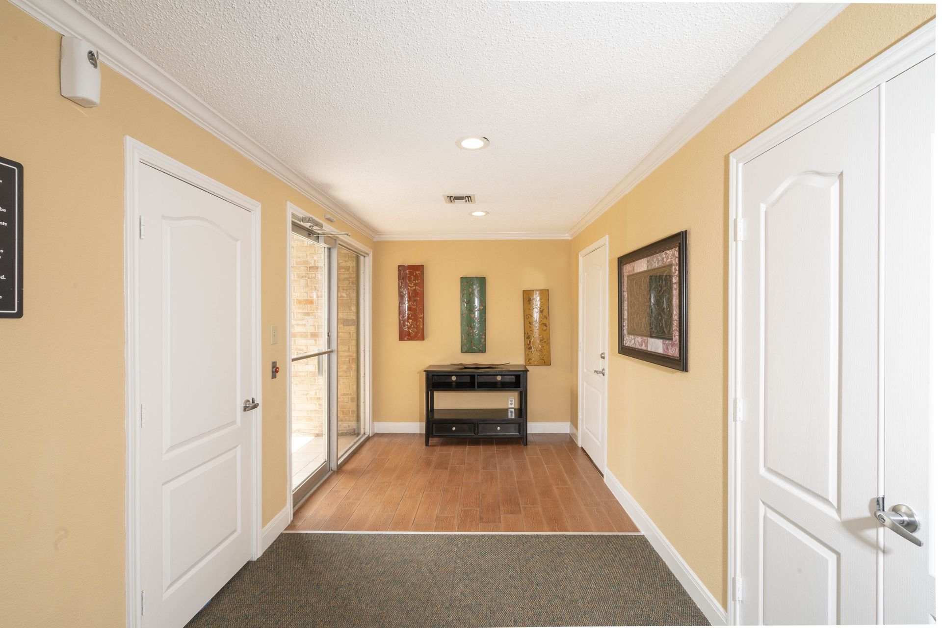 A hallway with white doors and a table in the middle