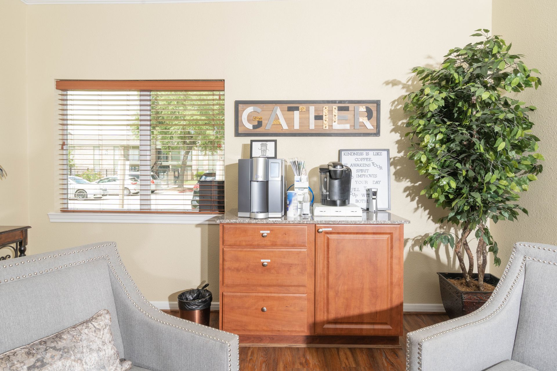 A living room with a couch , chairs , and a coffee bar.
