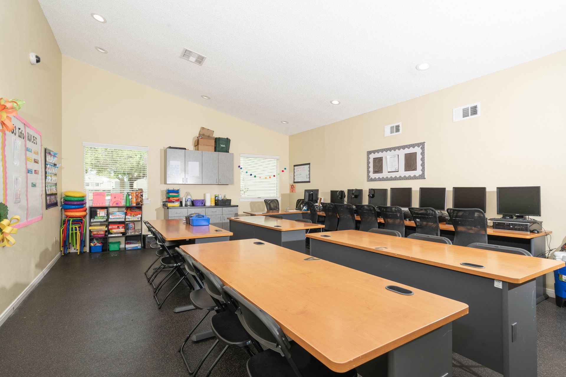 A classroom with a lot of tables and chairs and computers.
