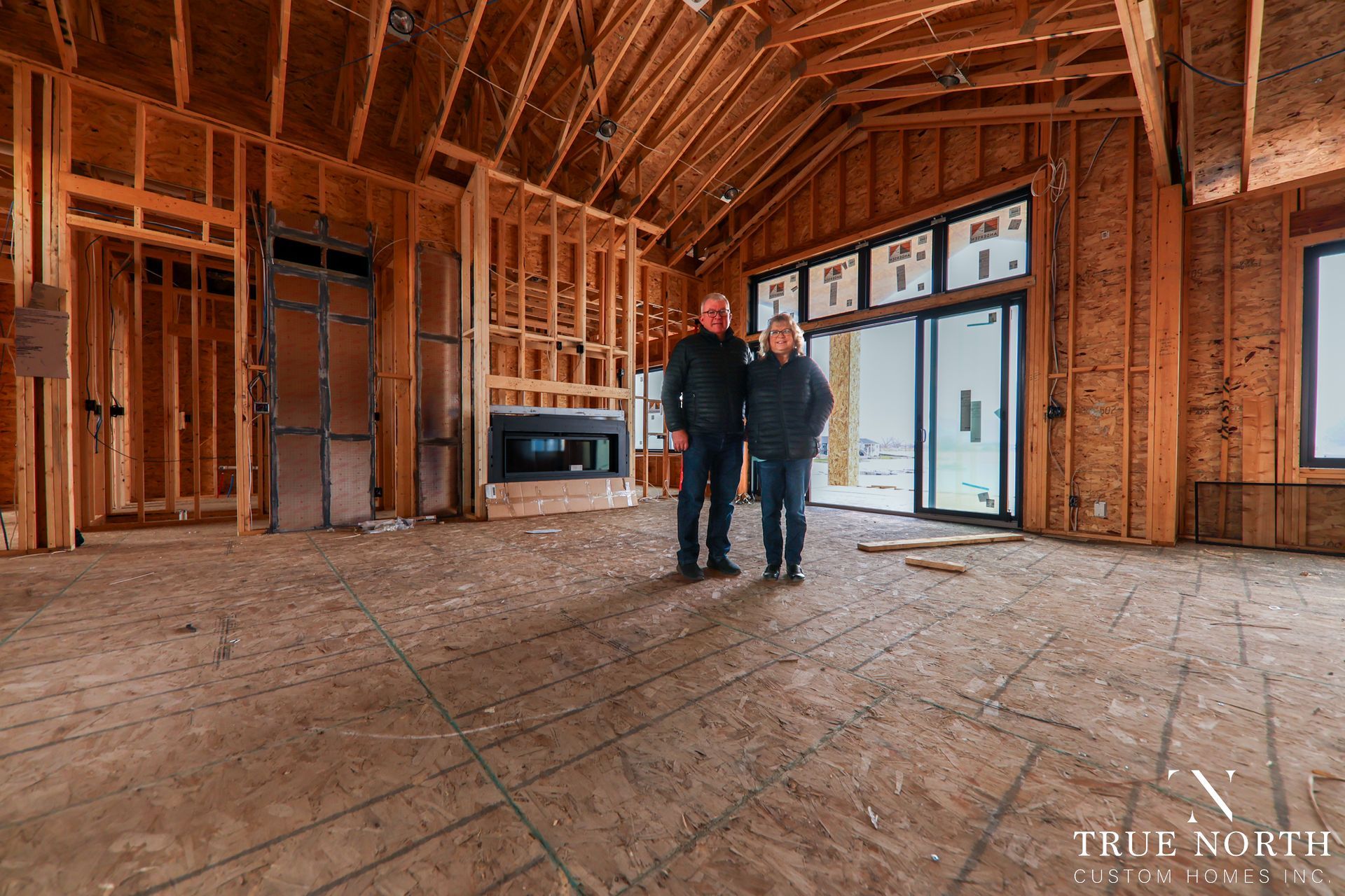 The Wyatt Family standing under the framing of their dream home.