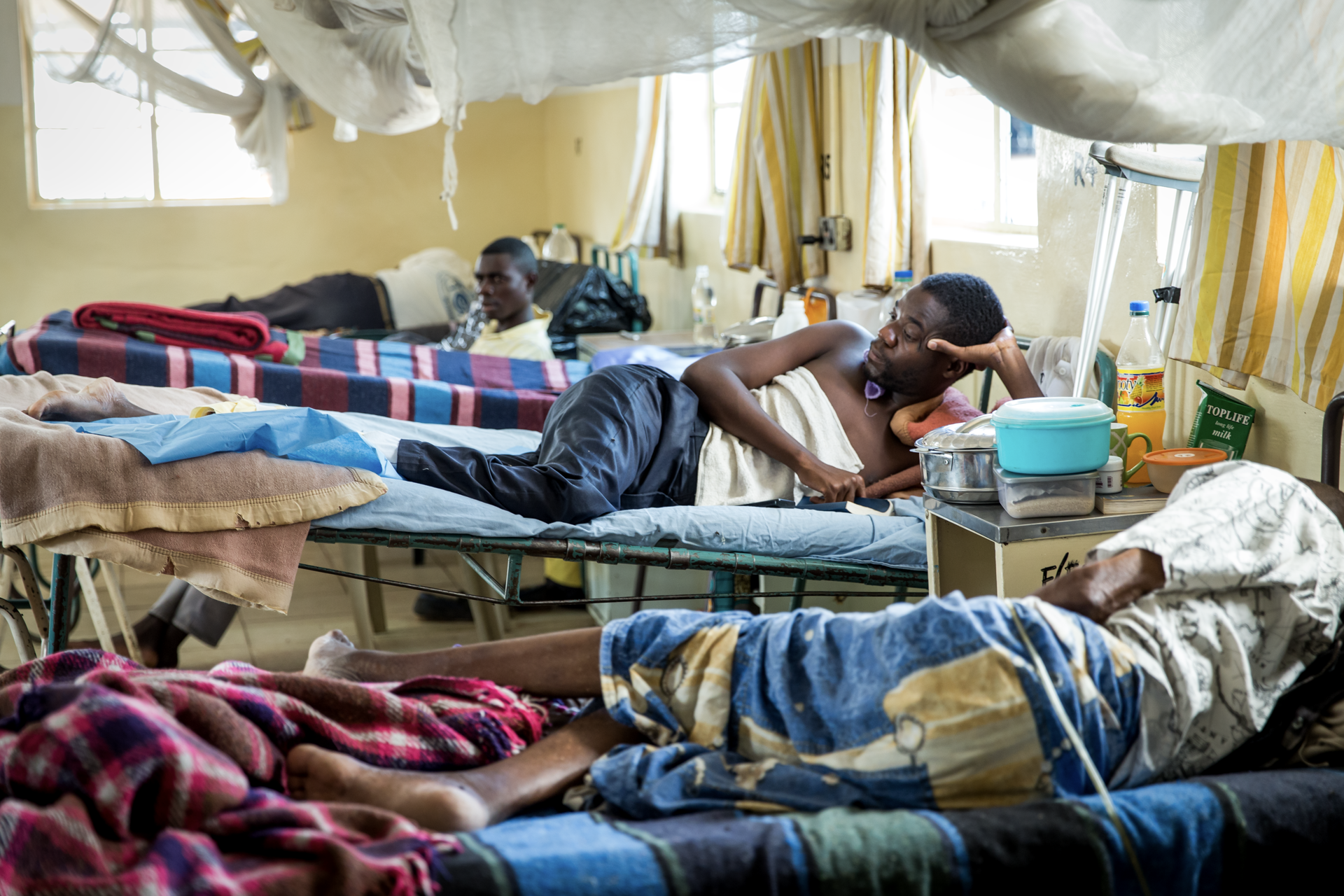a man is laying in a hospital bed with a container that says future life on it