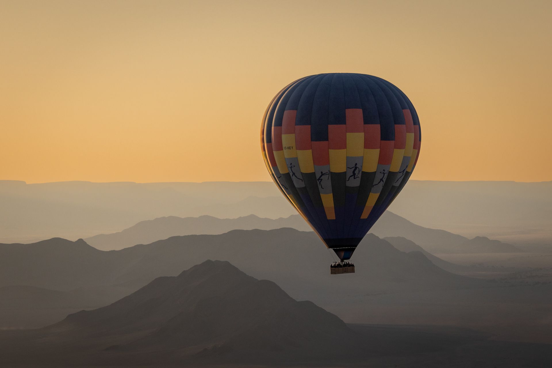 a hot air balloon is flying over a mountain range