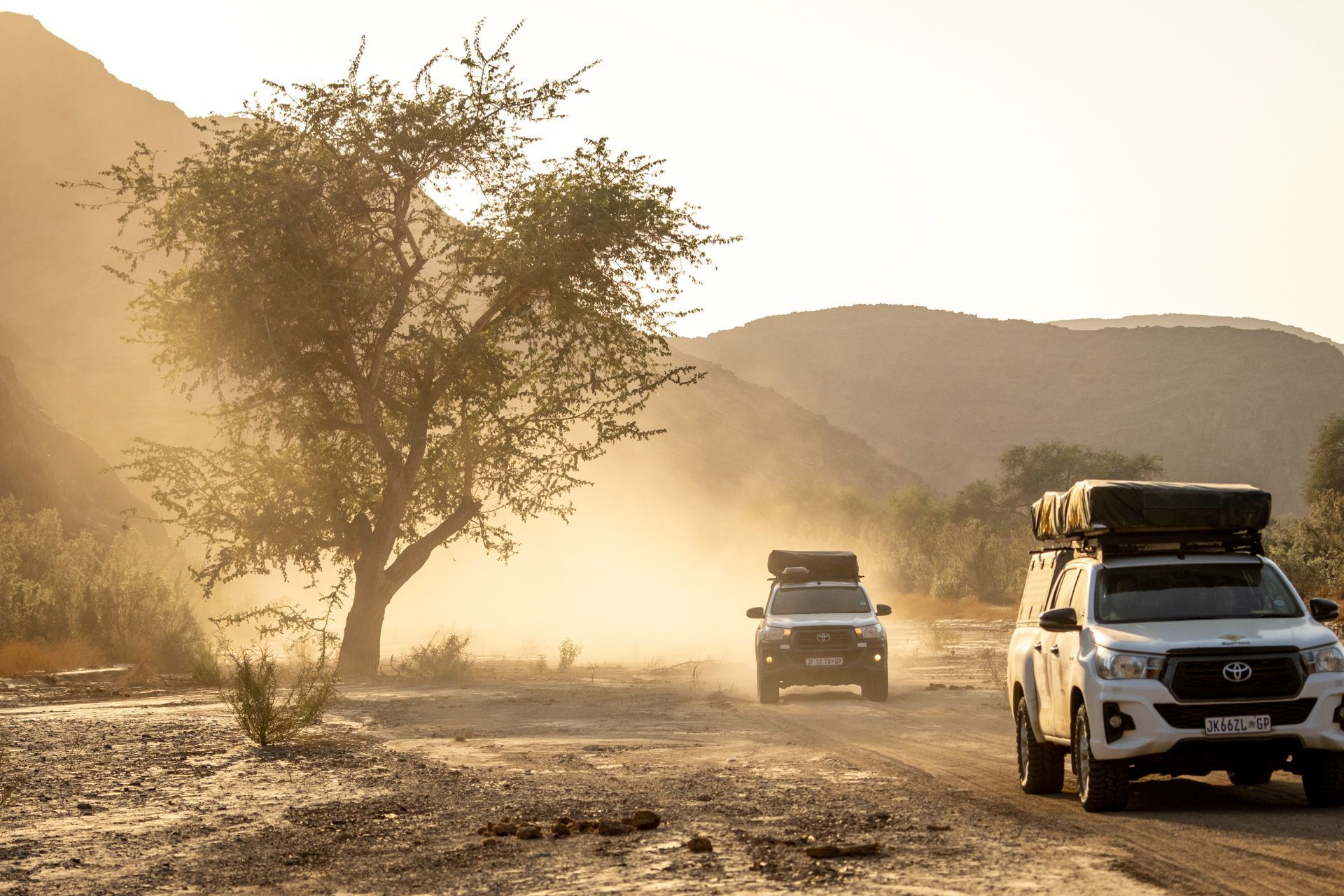 a toyota hilux is driving down a dirt road