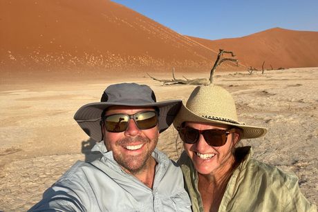 a man and a woman are posing for a picture in the desert