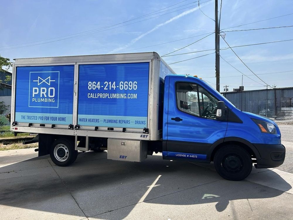 A blue Pro Plumbing service truck parked outdoors, featuring the company logo, phone number, and website on its side.