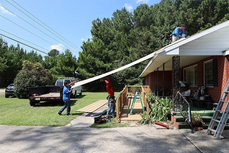 A group of men are working on the roof of a house.