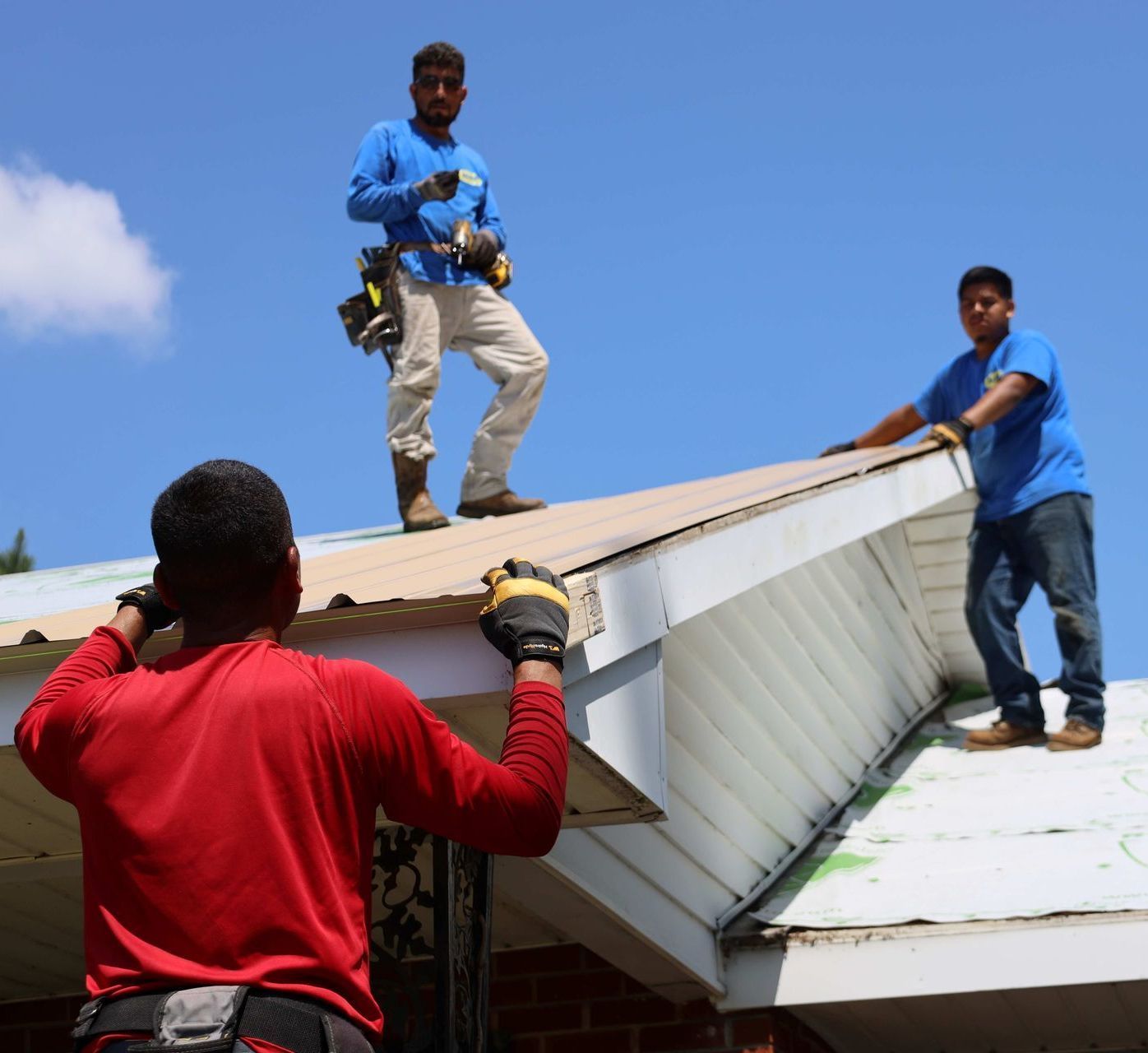 A man in a red shirt is standing on a roof