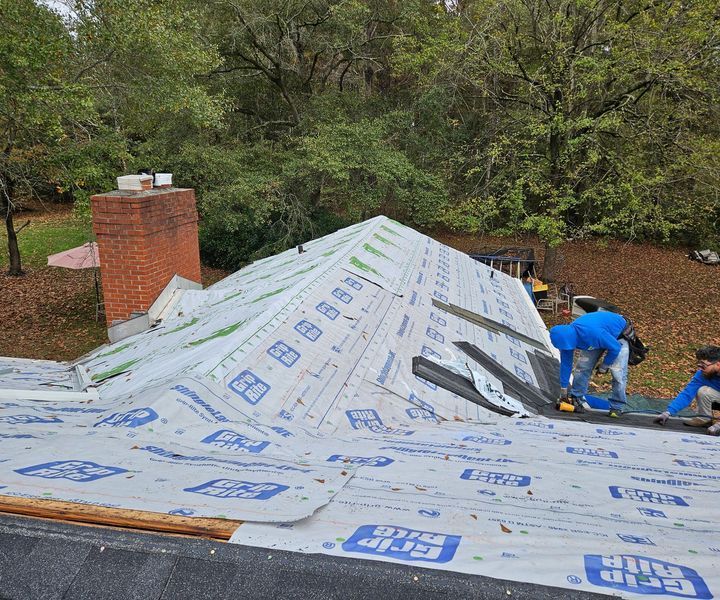 A group of men are working on a roof.