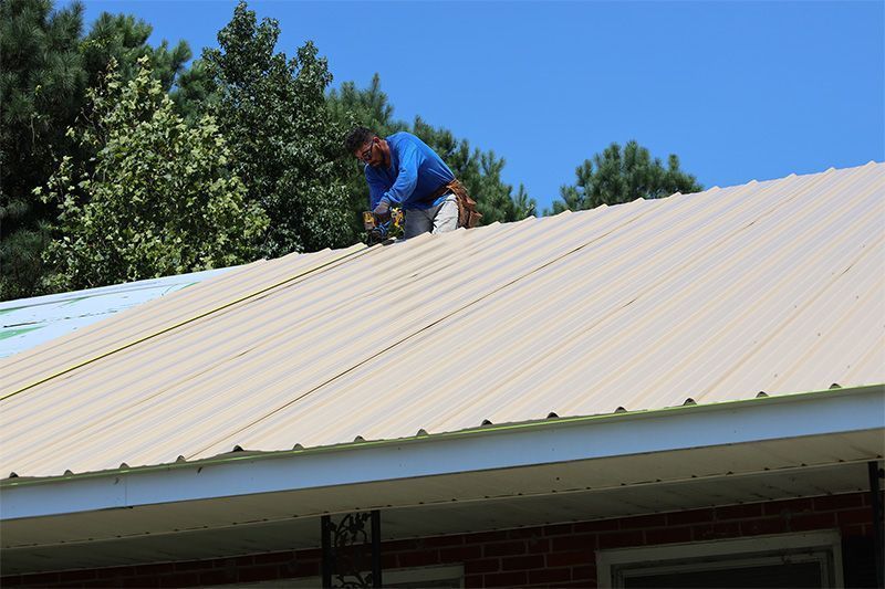 A man is working on the roof of a house.
