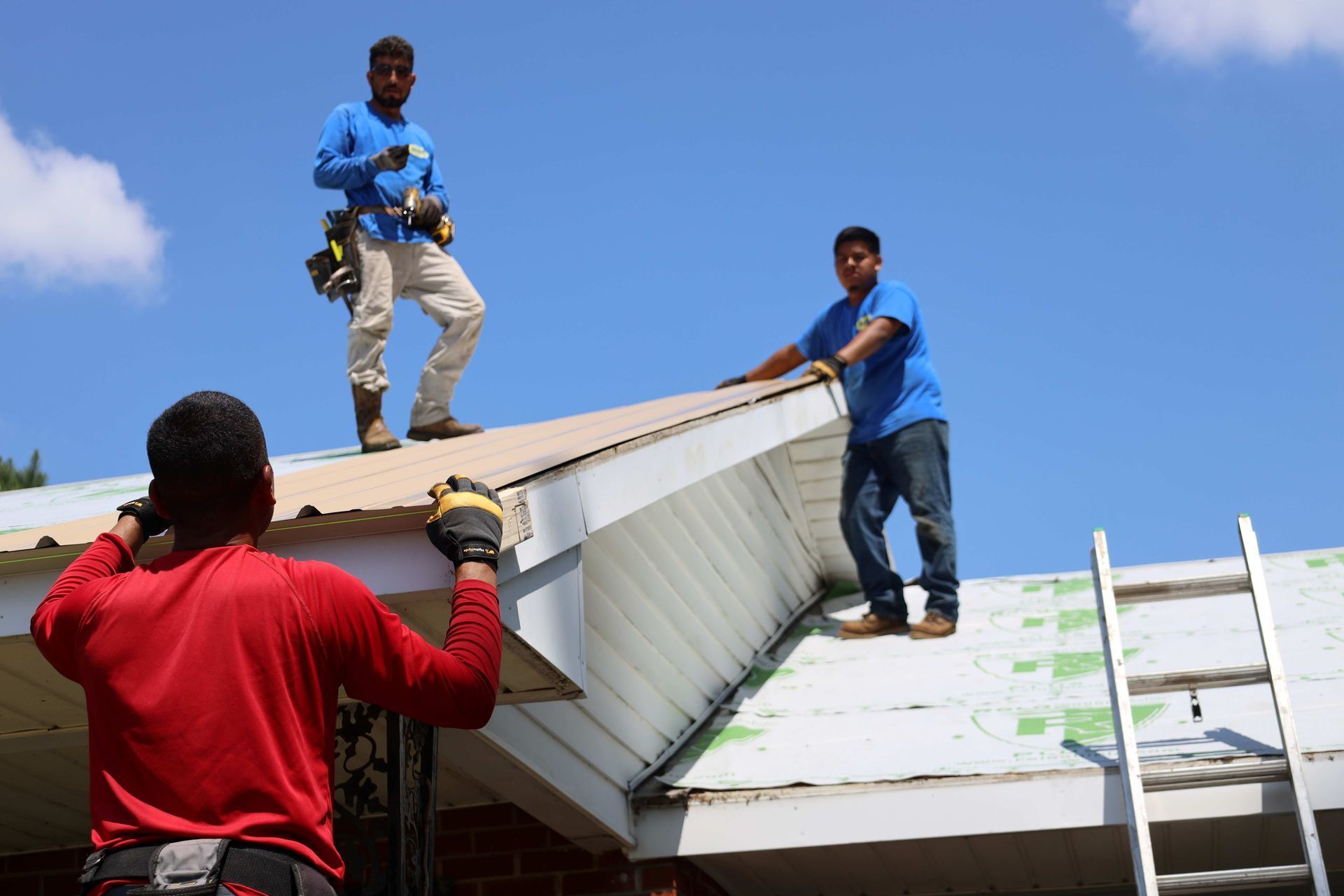 Two men are working on the roof of a house.