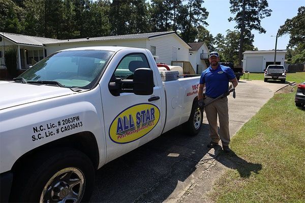A man is standing in front of an all star truck