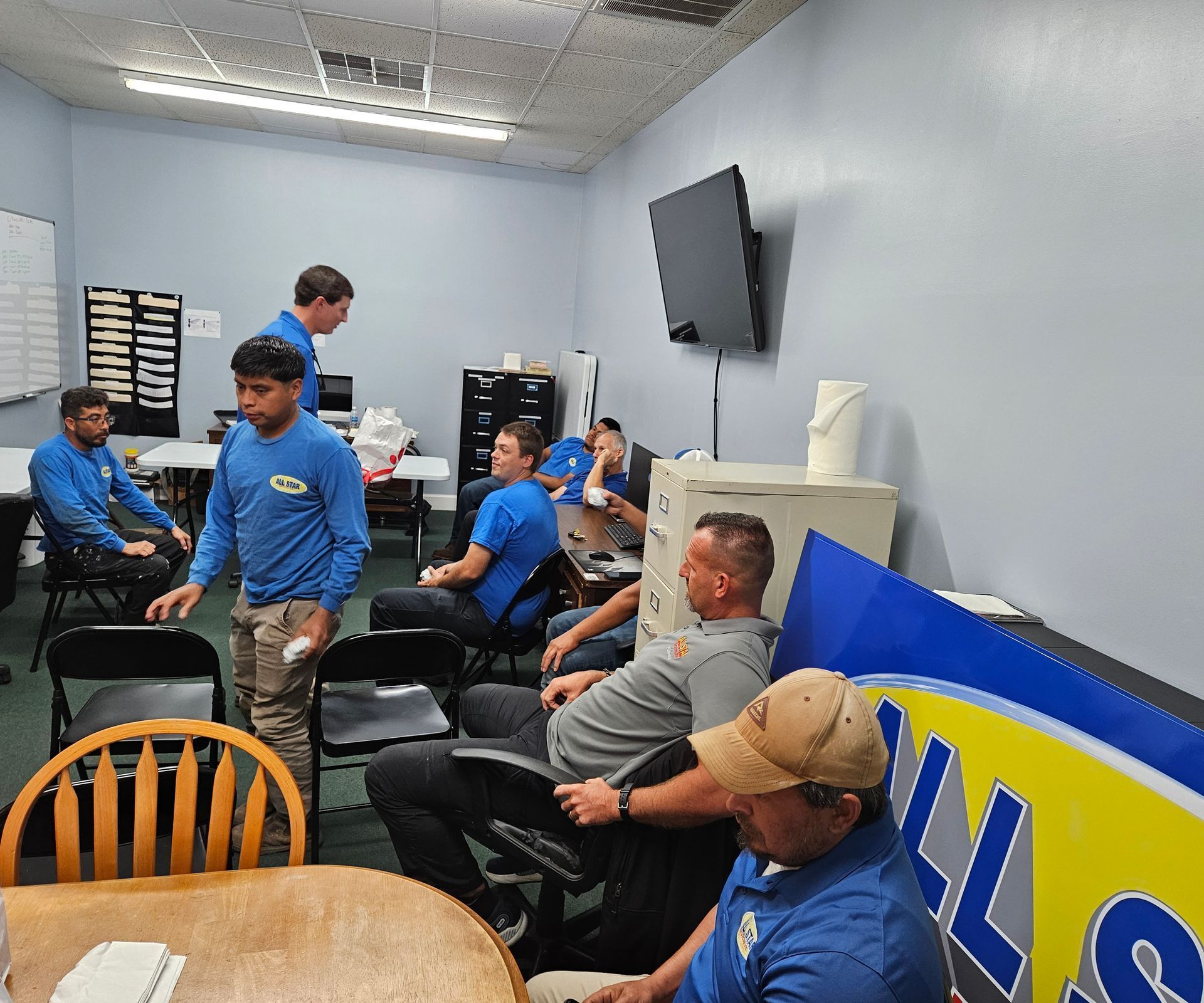 A group of men are sitting around a table in a room.