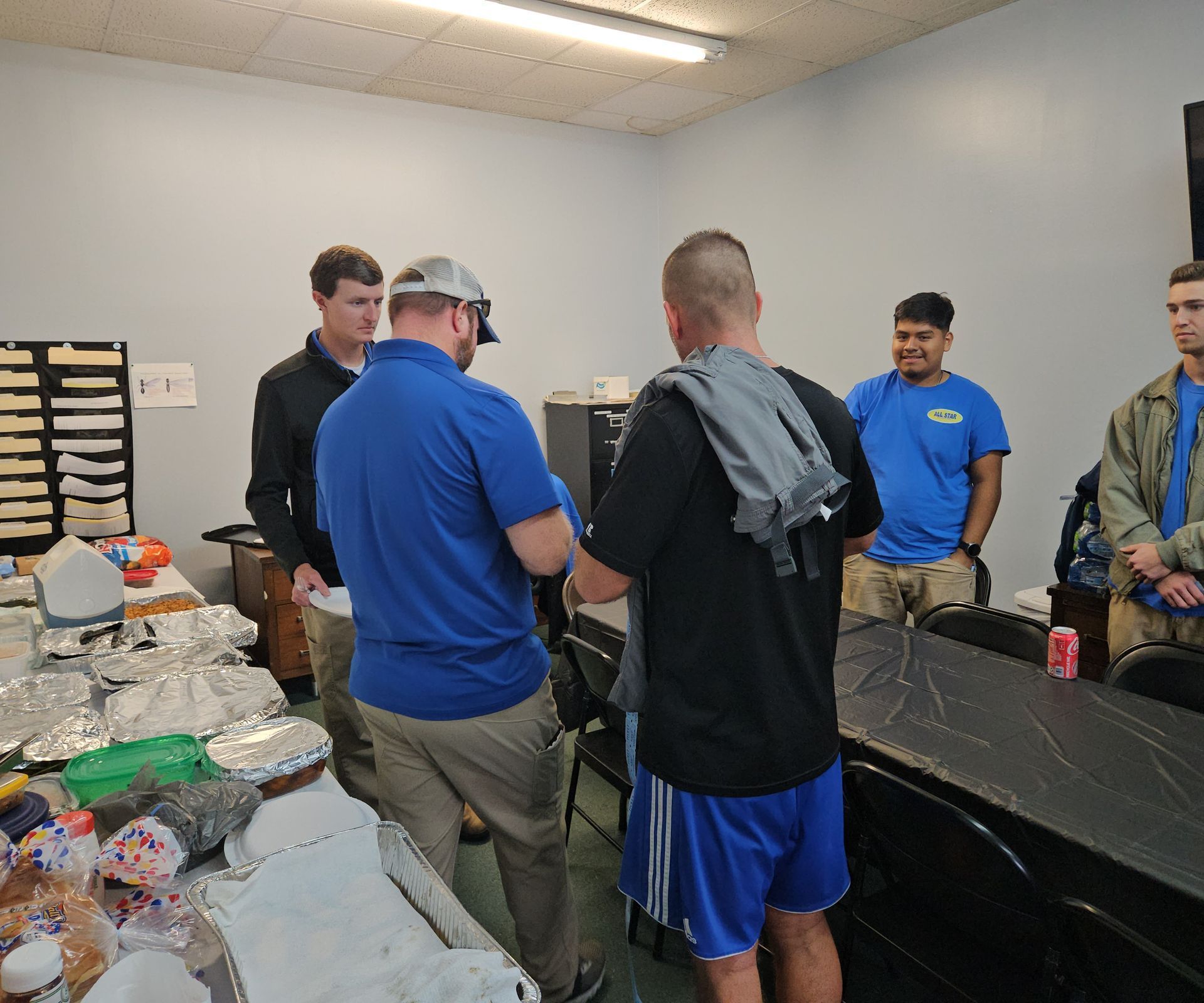 A group of men are standing around a table in a room