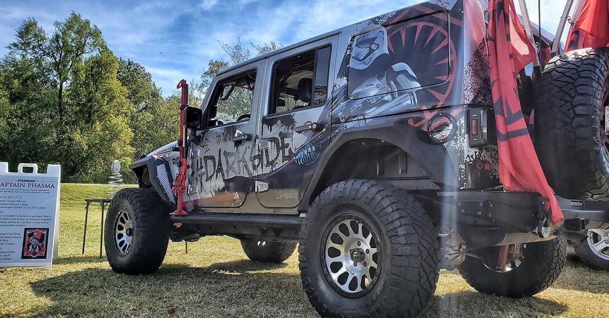 Star Wars themed Jeep with large tires parked outside, featuring graphics and accessories.