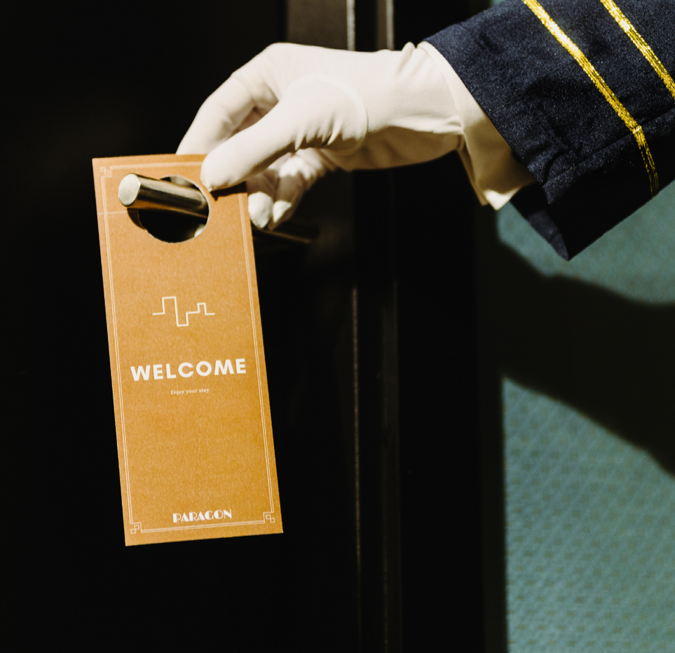 A person is holding a welcome sign in their hand