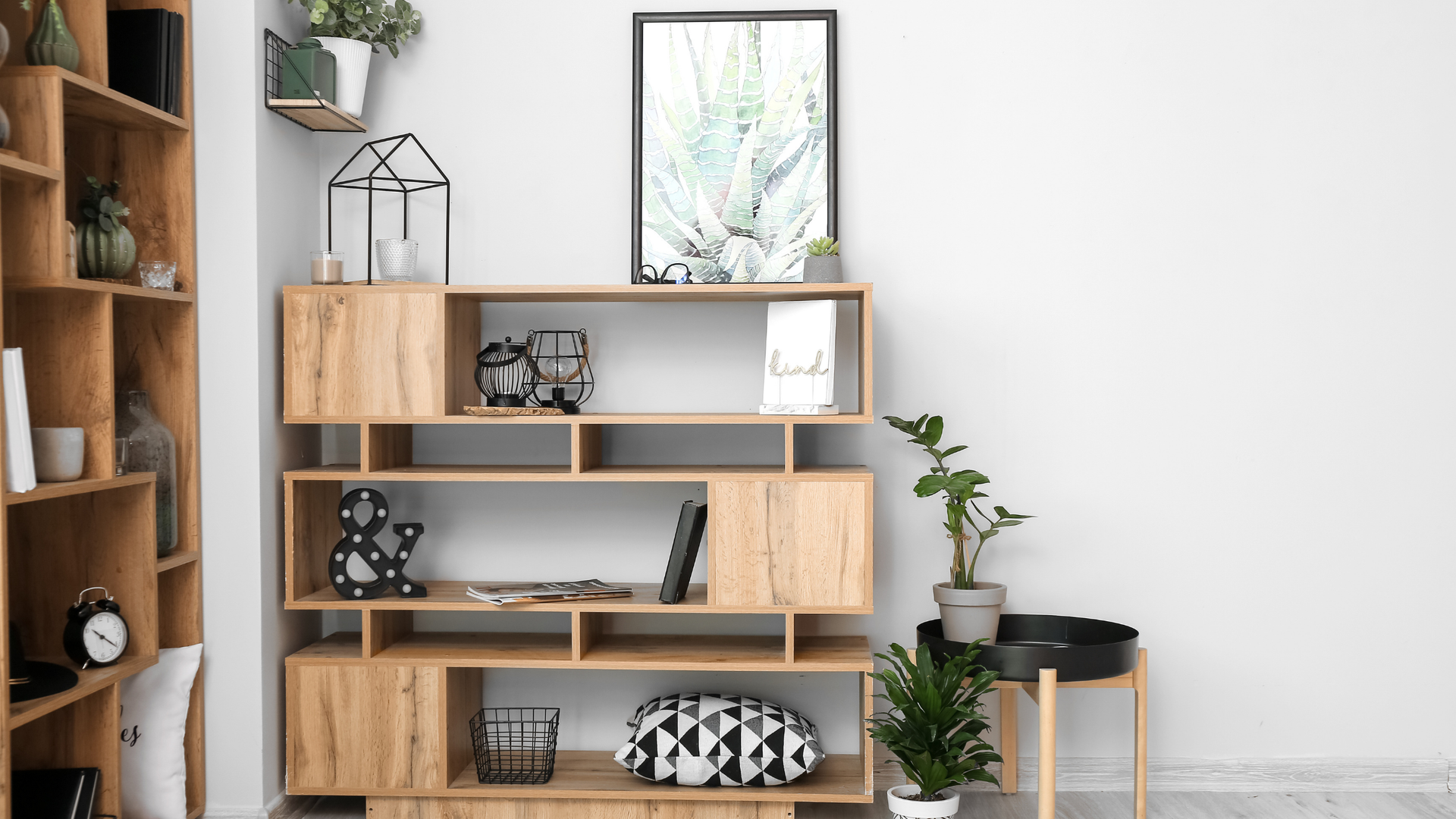 Wooden shelving unit with decor against a white wall.