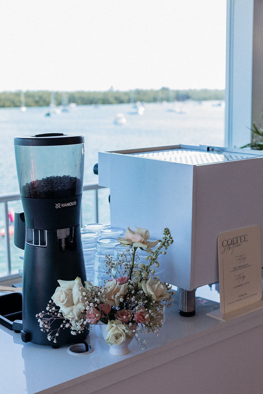 A coffee grinder is sitting on a counter next to a coffee machine. A coffee grinder is sitting on a counter next to a coffee machine.