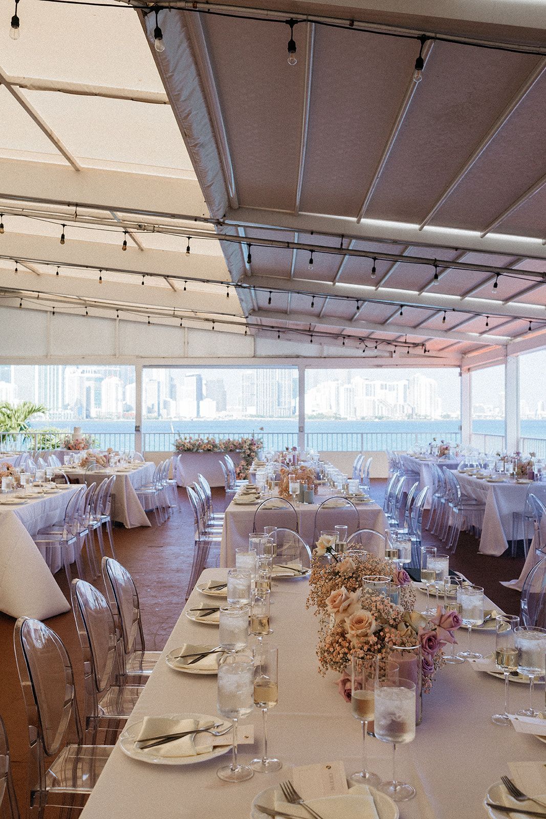 A large room with tables and chairs set up for a wedding reception. A large room with tables and chairs set up for a wedding reception.
