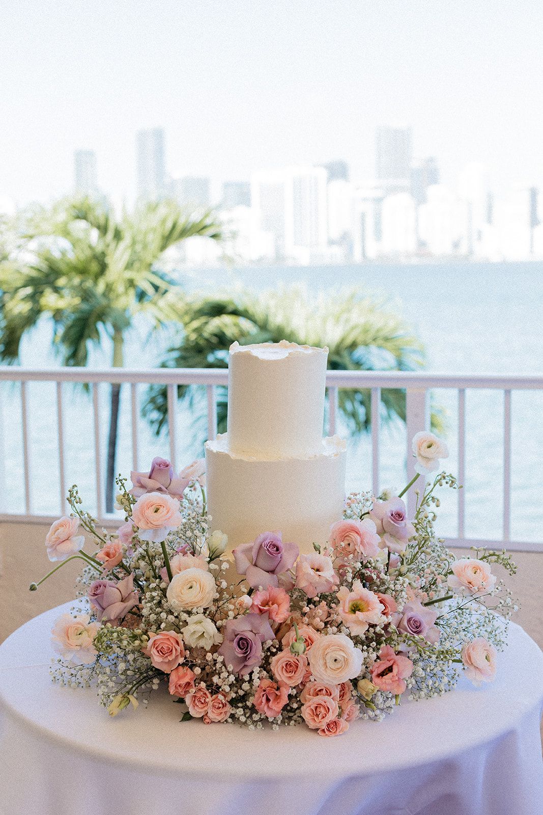 A wedding cake is sitting on top of a table decorated with flowers.