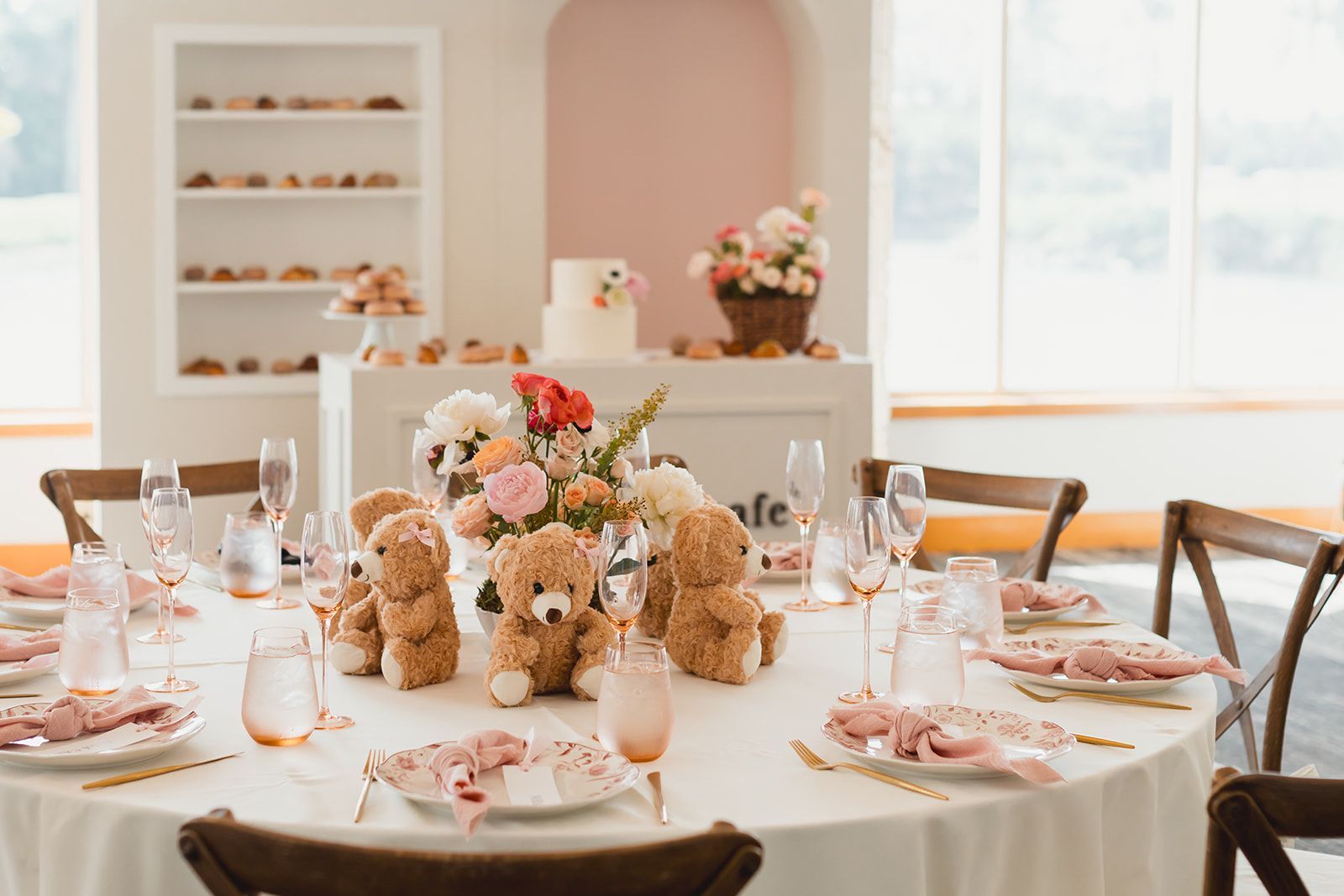 A long table in a restaurant with flowers on it A long table in a restaurant with flowers on it