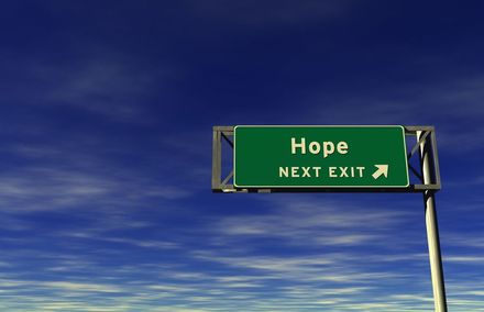 a green highway sign that says hope next exit