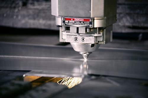 A machine is cutting a piece of metal with a laser.