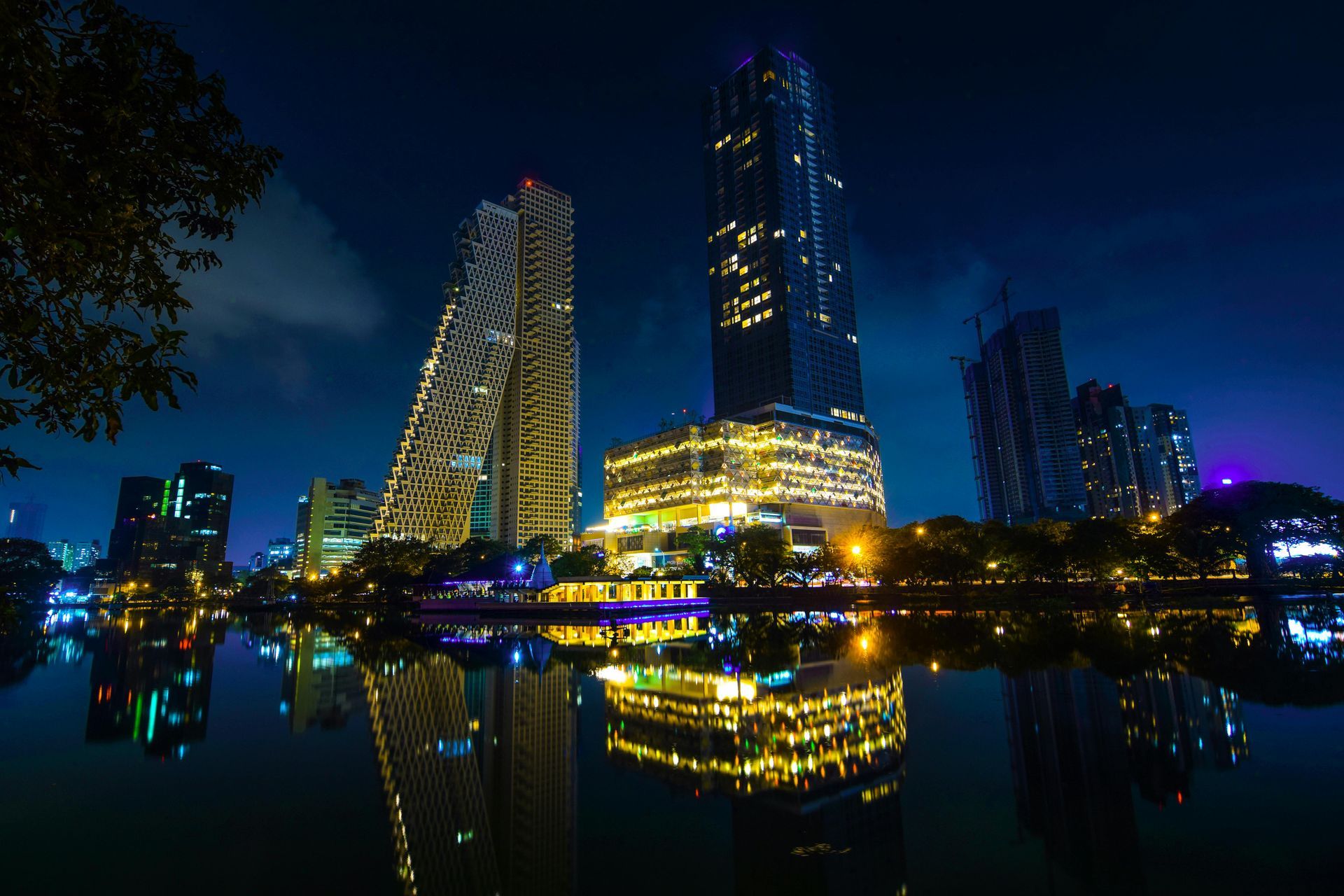 A city skyline at night with a lake in the foreground.