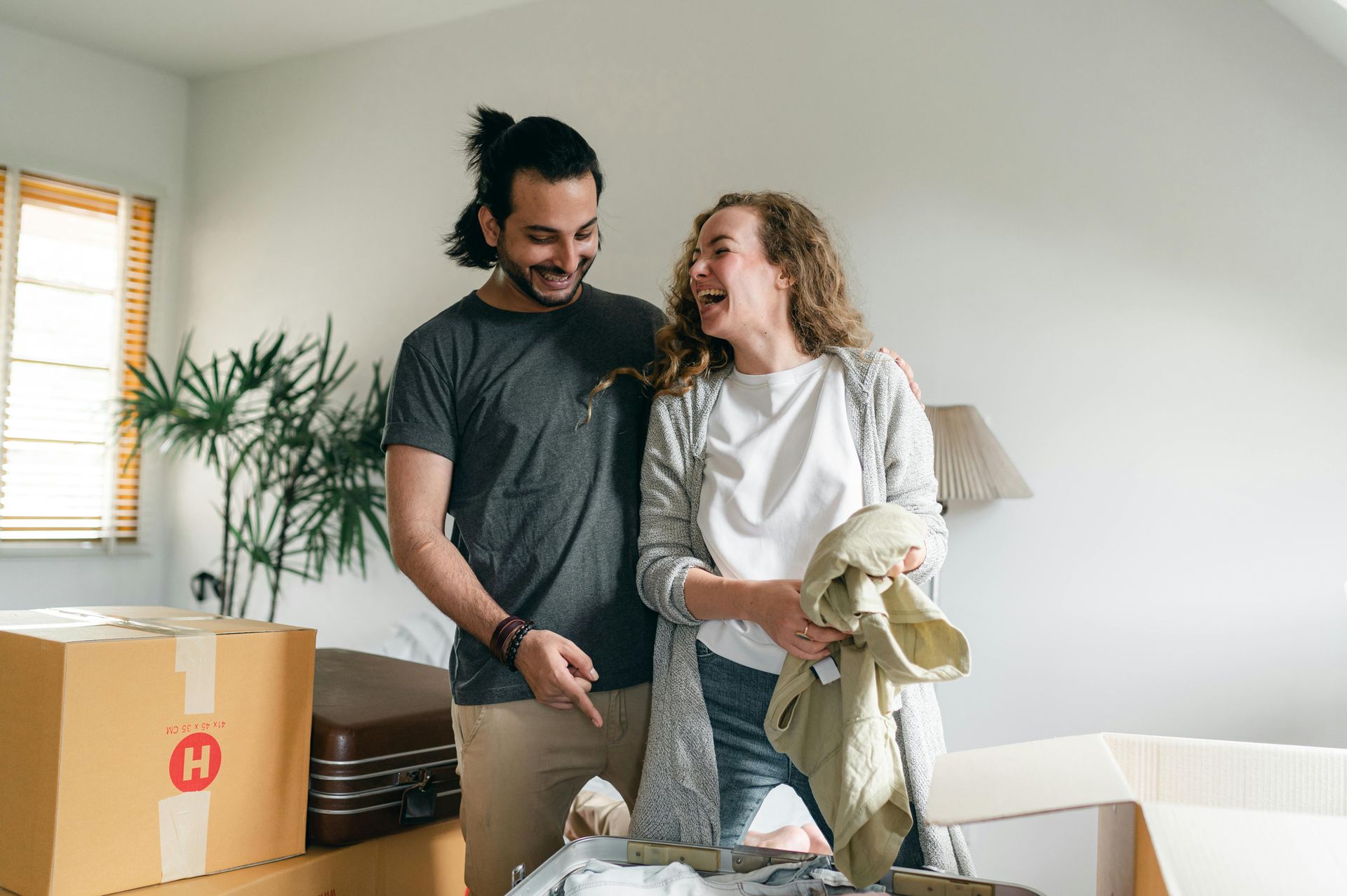 A man and a woman are standing next to each other in a living room.