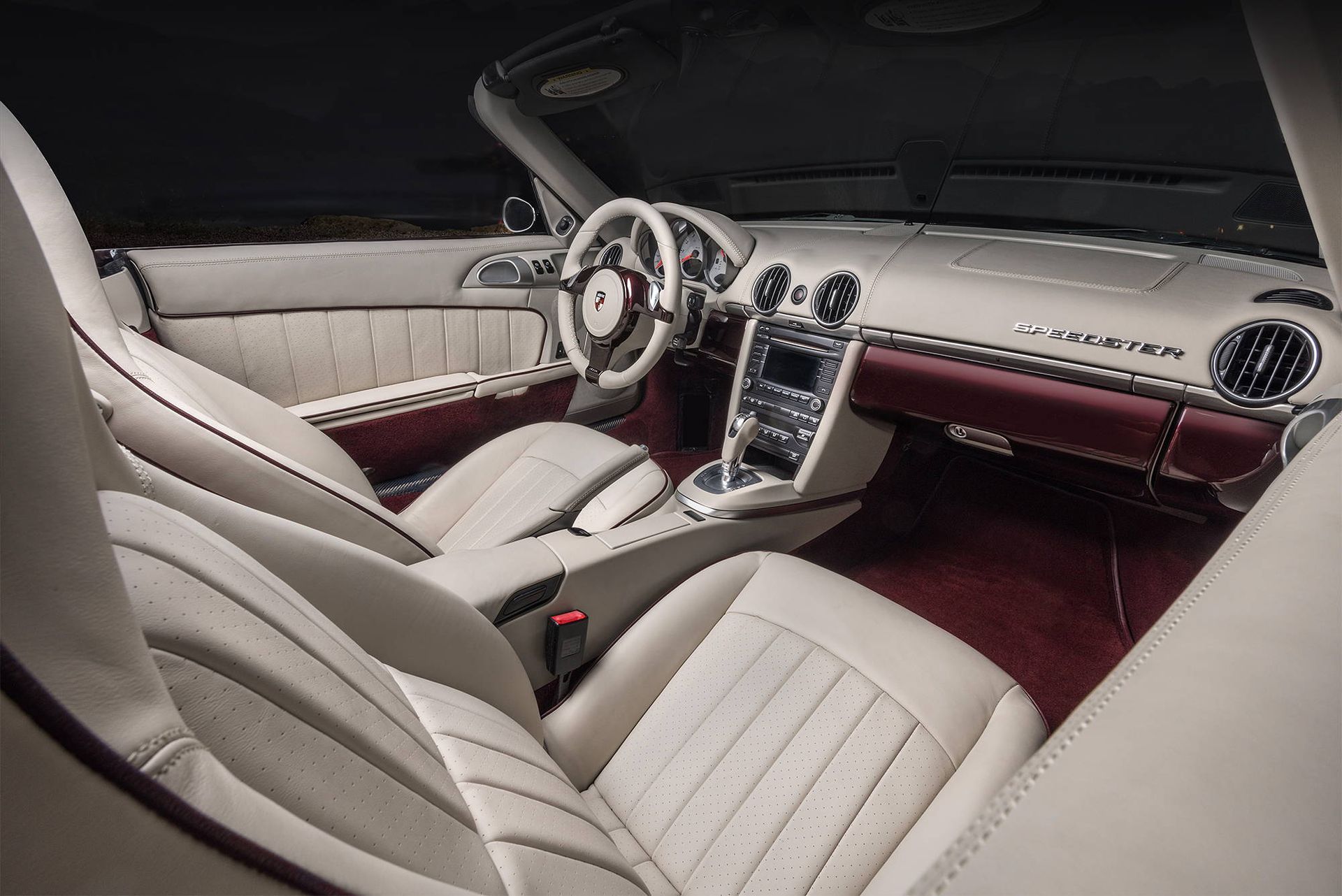 The interior of a car with white leather seats and a steering wheel