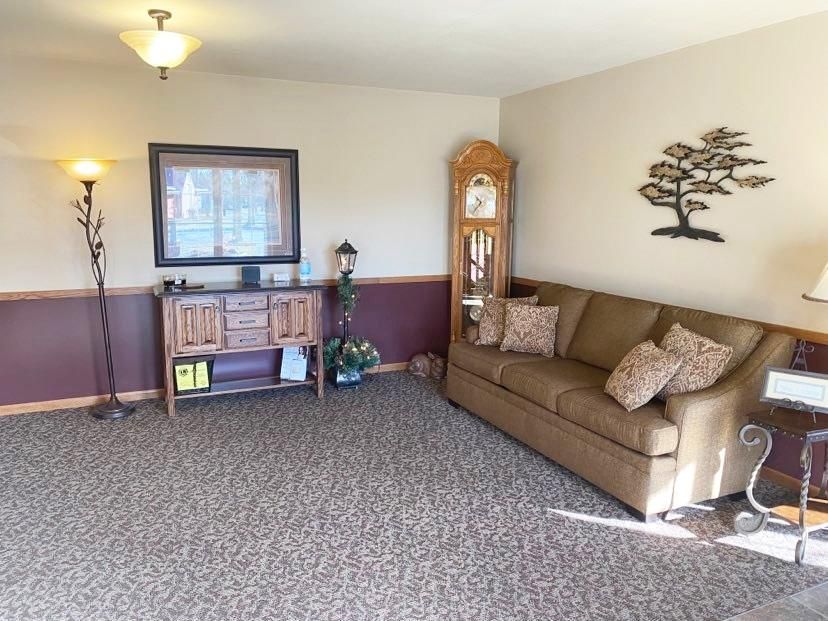 The front door of a house with a porch and plants in front of it.