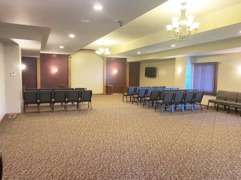 A living room with a couch , chairs , and a coffin.