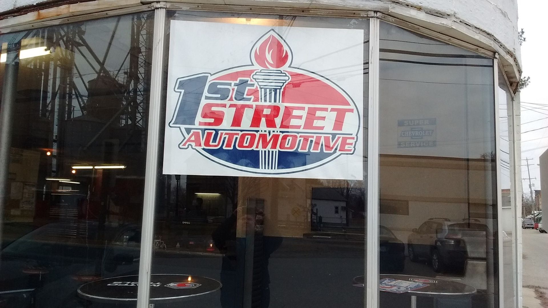 A 1st Street Automotive business sign displayed on a large glass window of an automotive shop.