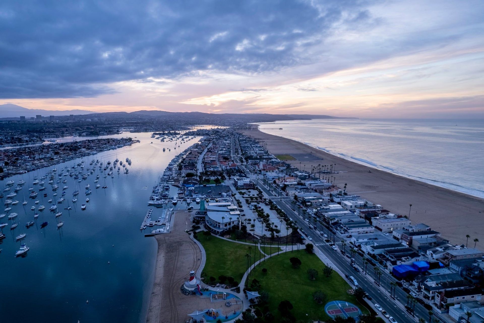 An aerial view of a city next to a body of water at sunset.