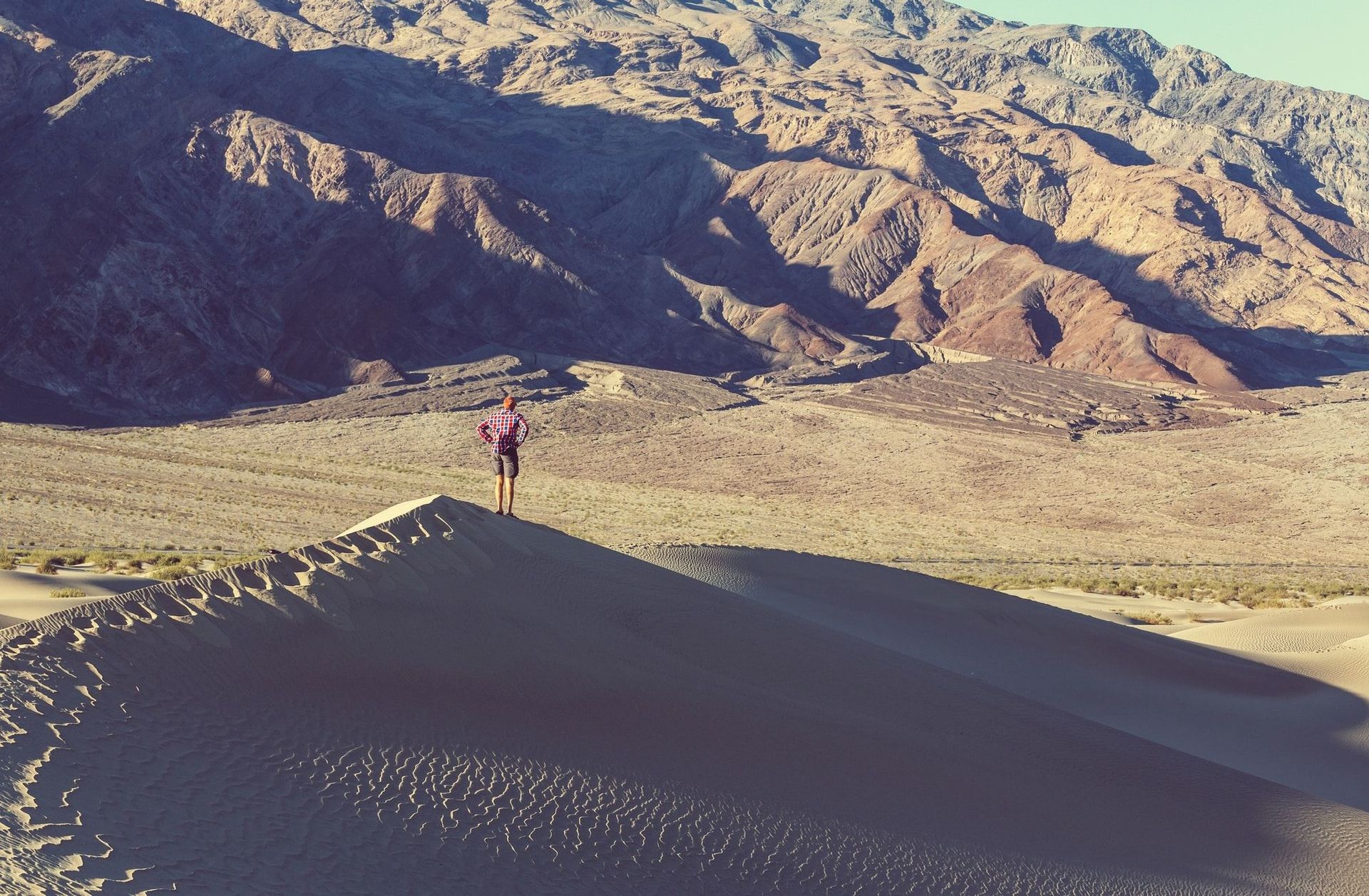 A person standing on top of a sand dune in the desert
